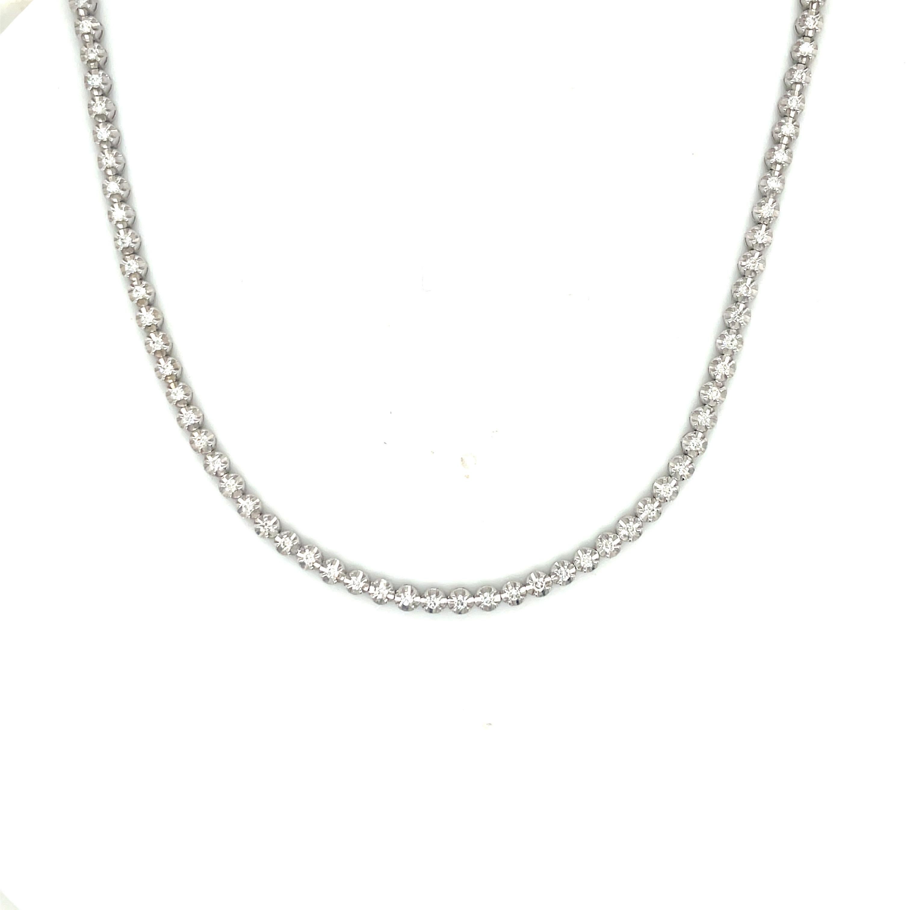 14 Karat White gold tennis necklace featuring 73 round brilliants weighing 1.03 carats in an illusion setting.
Color G-H
Clarity SI

Total length: 14.5 Inches
Diamond Length: 9 Inches
Chain Length: 5.5 Inches
Can be wrapped around the wrist twice as