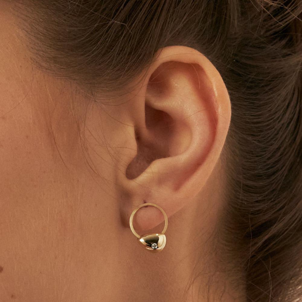Introducing the 14K Solid Gold Diamond Circle Earrings, a manifestation of Orena Jewelry's commitment to exceptional artisanship. Each earring is delicately handcrafted, radiating a blend of opulence seamlessly paired with timeless elegance. This