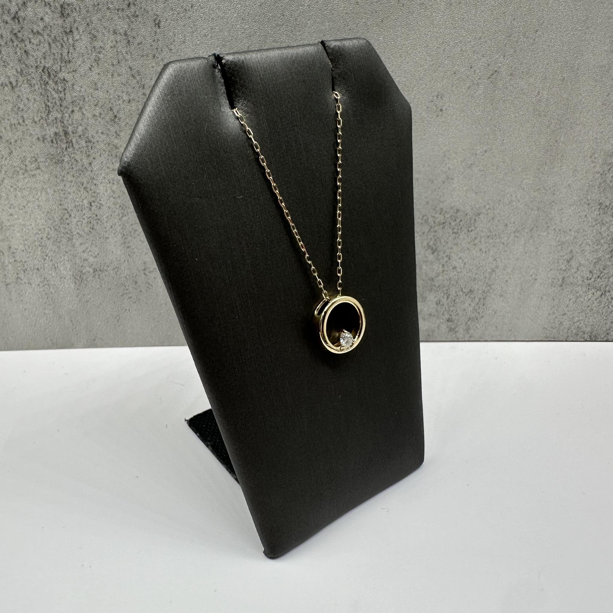 This elegant diamond circle necklace in 10kt yellow gold features 0.10 carats total weight of natural HI I1 round diamonds set in a timeless open-circle design. The sparkling diamonds beautifully complement the warm tone of yellow gold, creating a