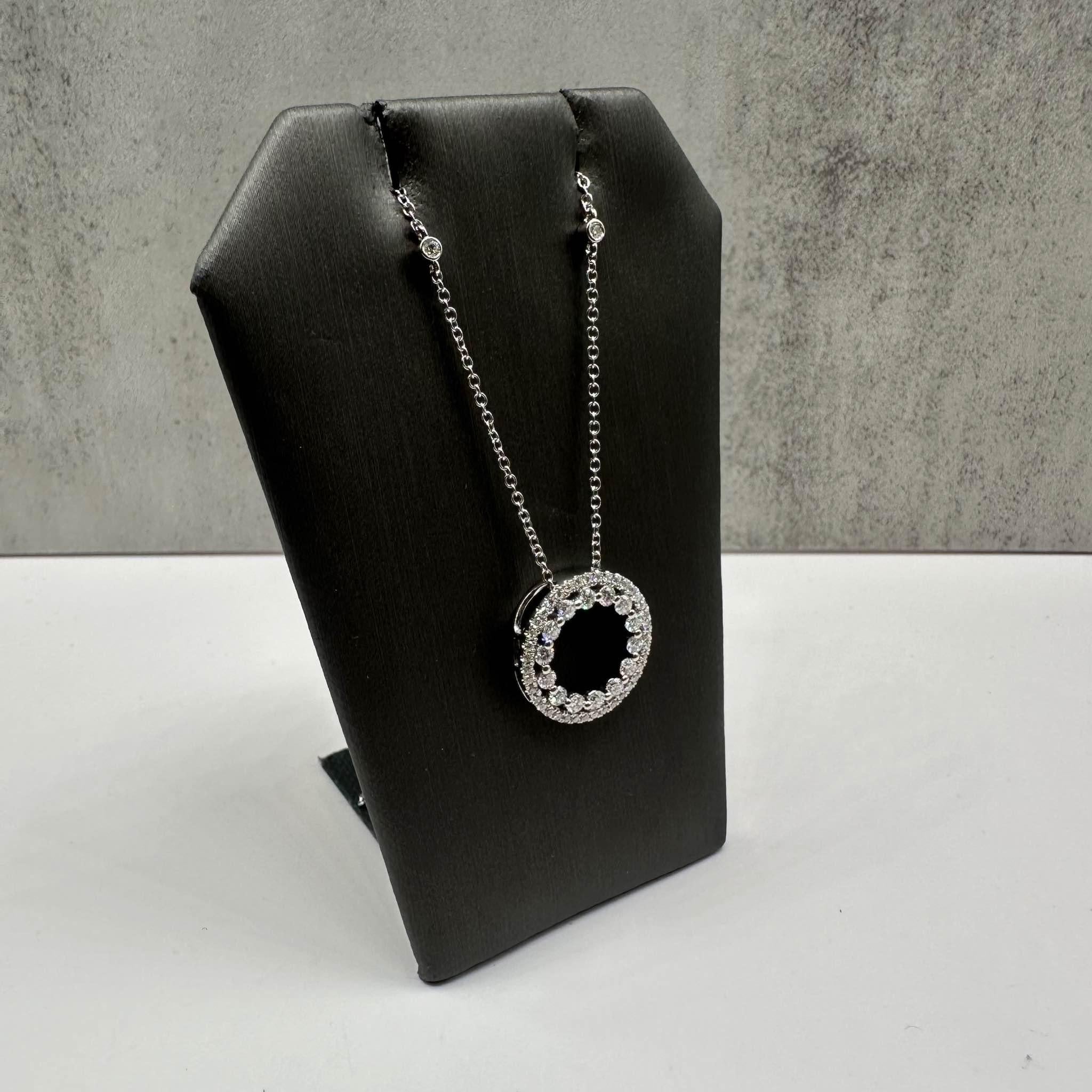 This elegant Diamond Circle Necklace in 18kt white gold features 0.83ctw of natural GH SI round diamonds, creating a sparkling and timeless design. The necklace is adjustable between 16 and 18 inches, offering versatility for different necklines and