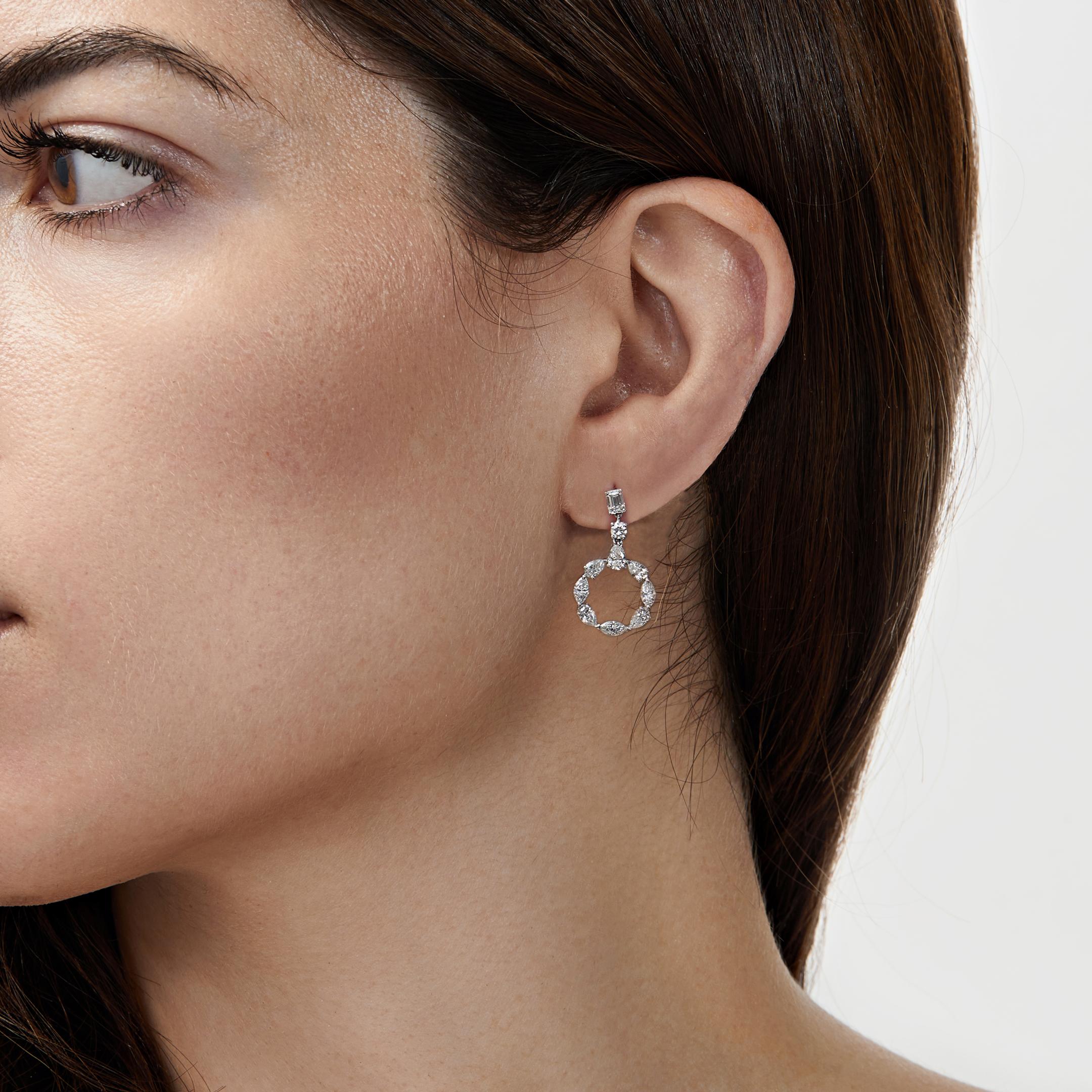 Un mélange de diamants taillés coalescent pour créer une silhouette frappante dans les boucles d'oreilles à découpe circulaire en diamant. Les clous d'oreilles en diamant taille émeraude descendent dans une combinaison de diamants en forme de poire