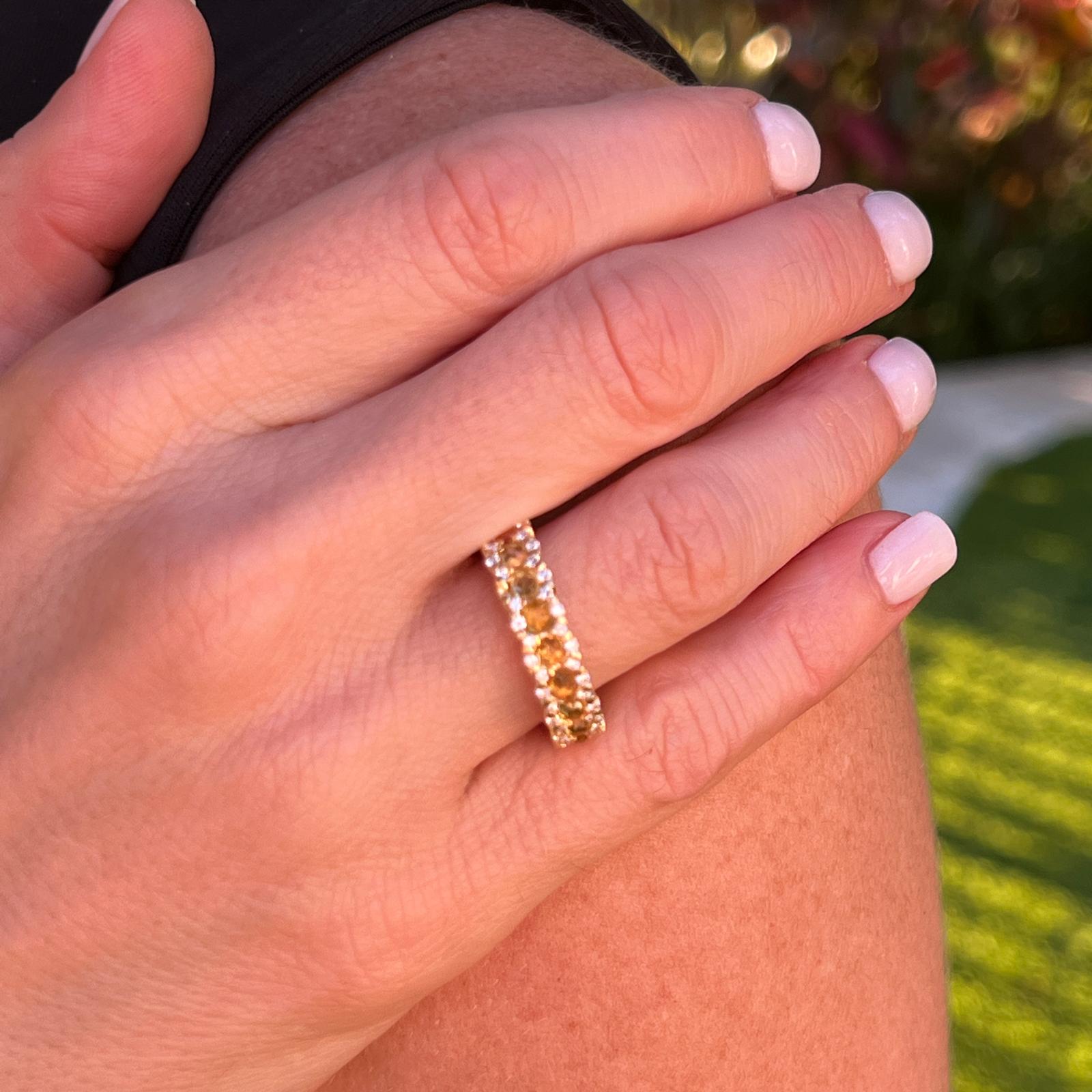 Gorgeous diamond and citrine eternity band crafted in 18 karat yellow gold. The band features round citrine gemstones and 80 round brilliant cut diamonds weighing approximately 1.04 CTW. The diamonds are graded G-H color and VS clarity. The ring