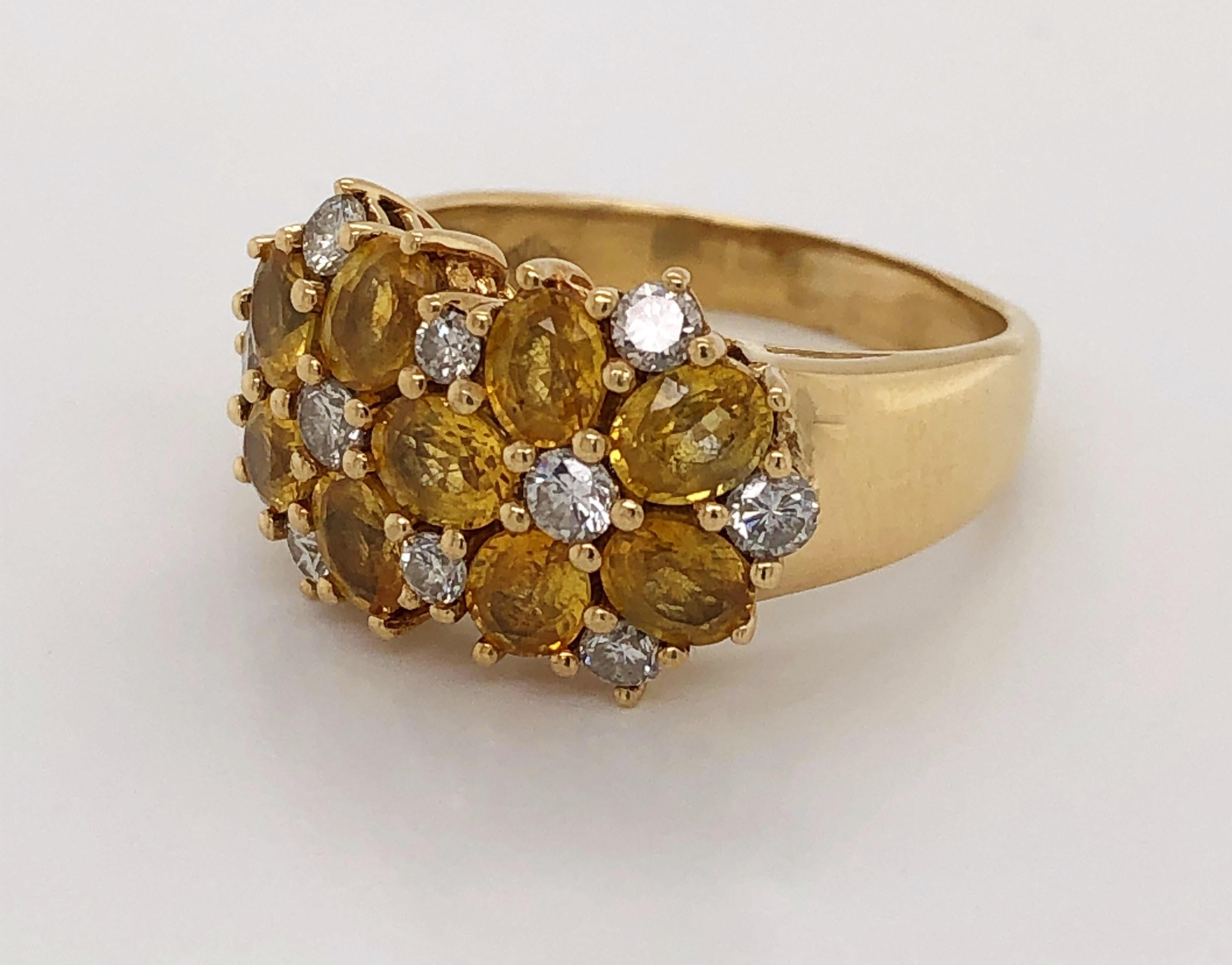 Radiant combination of sunny citrine gemstones and bright white diamonds create this cheerful cluster cocktail ring. With a graduated band in eighteen karat 18K yellow gold, the dazzling floral cluster head, measuring approximately 12.8 mm H x 19 mm