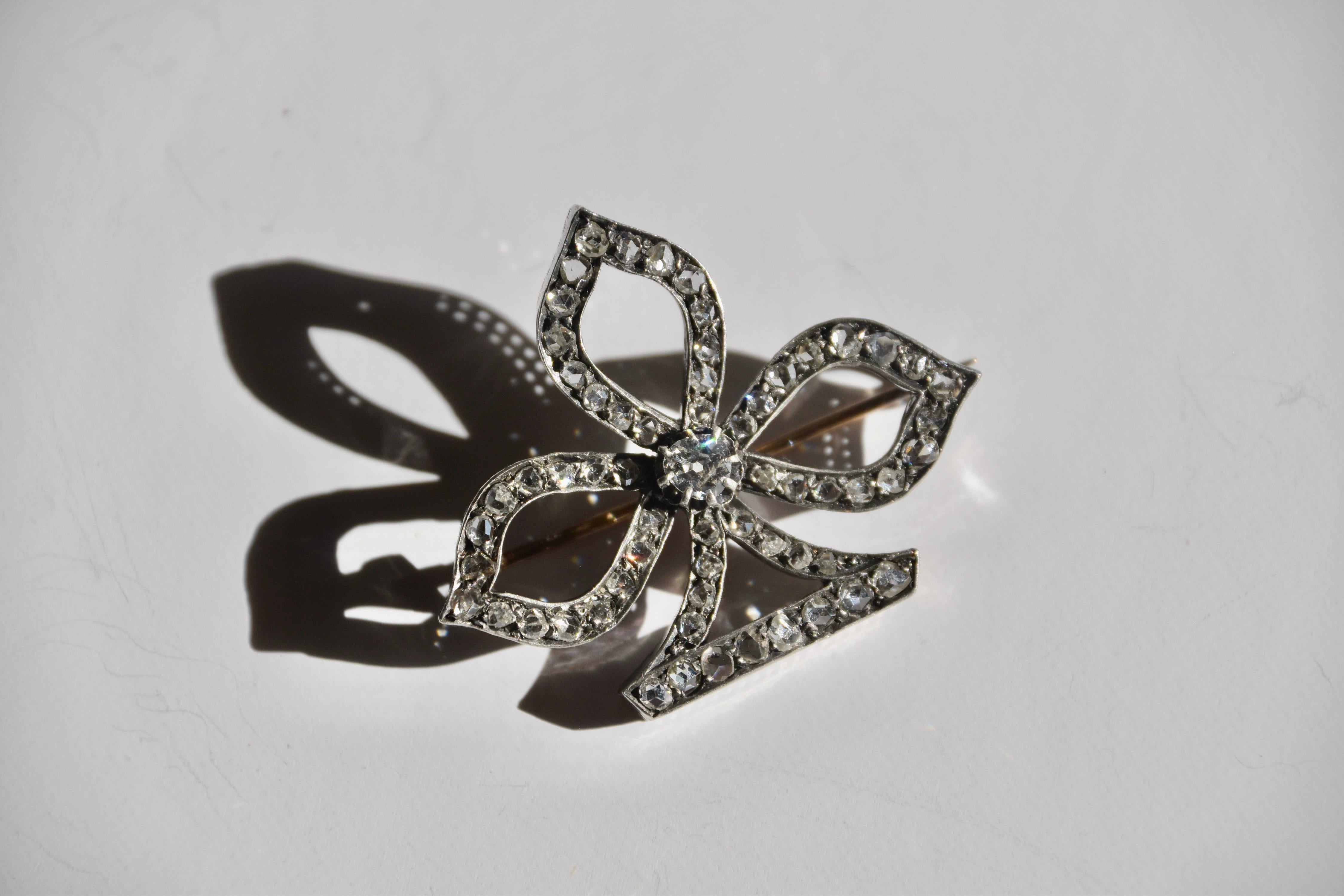 Broche en argent et en or de la fin du XIXe siècle, représentant un jeu de cartes de trèfle. Serti de diamants taille rose et taille ancienne, le poids estimé du diamant taille ancienne est de 0,3 carats, couleur G-H, pureté VS. 

Longueur