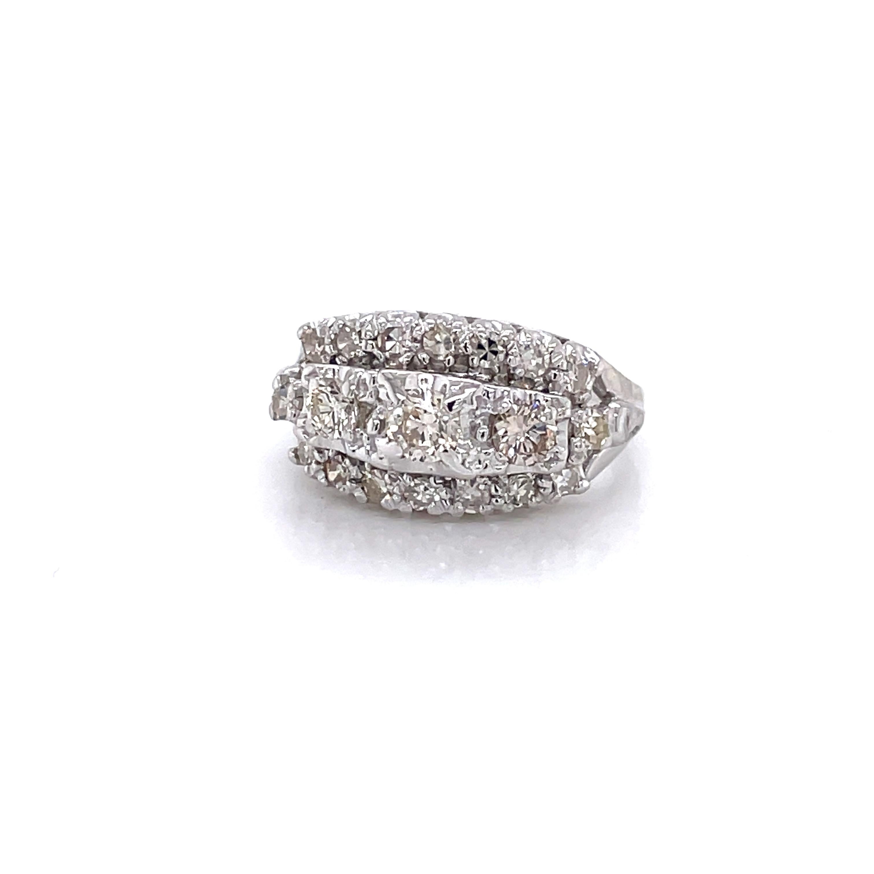 Trente et un diamants ronds facettés H/VS, d'un poids total de 0,52 carats, couronnent généreusement le style dôme de cette impressionnante bague de fiançailles en or blanc quatorze carats (14K).
Trois rangées de diamants étincelants couronnent la