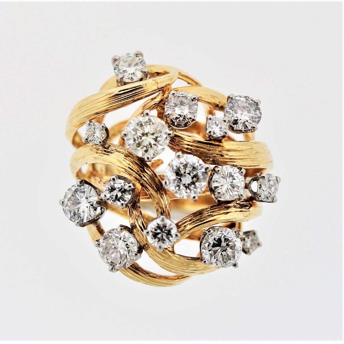 A bold and creative cocktail ring featuring a cluster of 15 large round brilliant-cut diamonds. They are set on twisting branches of yellow gold which have been hand-carved and textured. The diamonds in total weigh approximately 5 carats. Made in