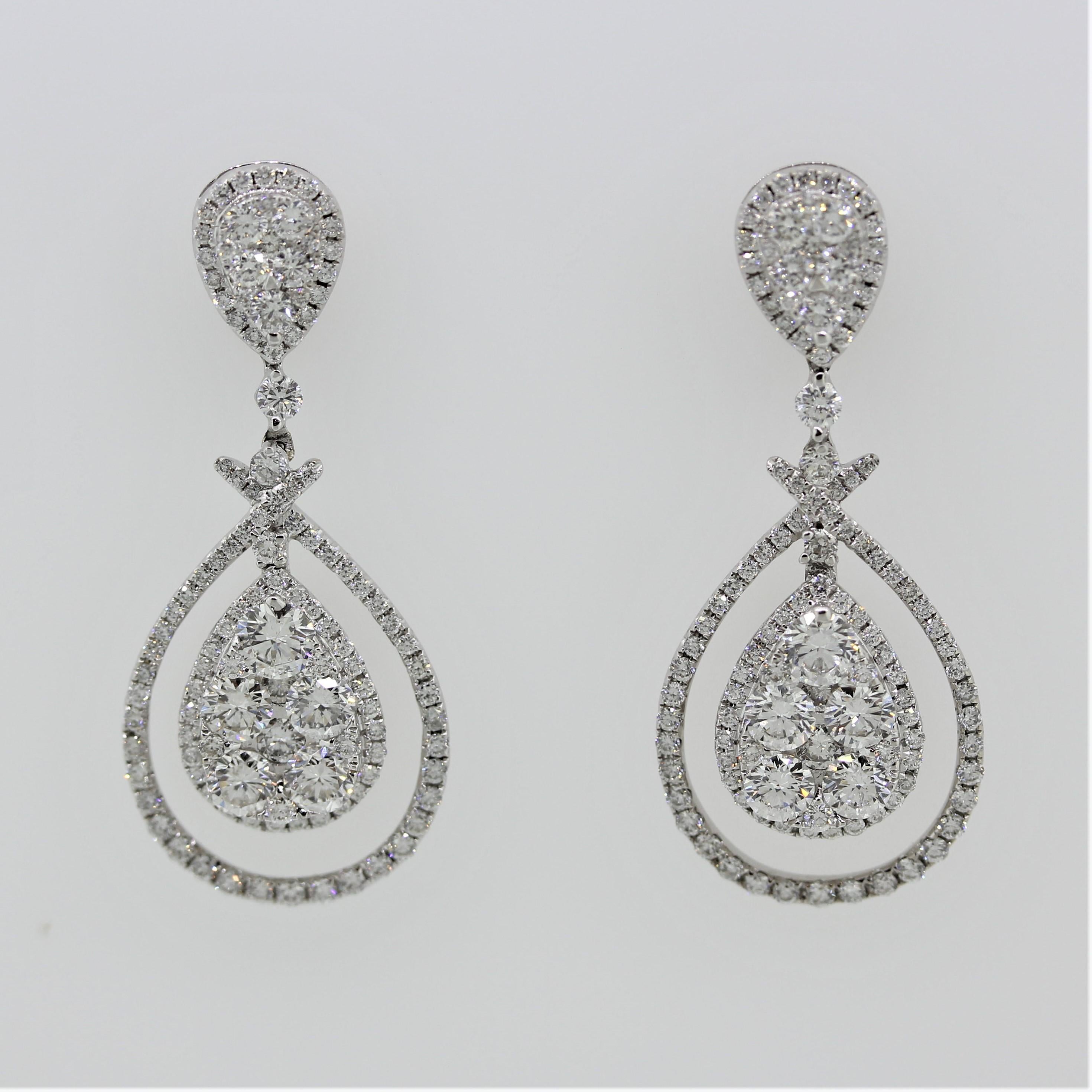 A special pair of earrings featuring a total of 3.45 carats of round brilliant cut diamonds. They are set around the border of the earrings as well as in pear shaped clusters which drop and dangle in the center of the earring. Made in 14k white gold