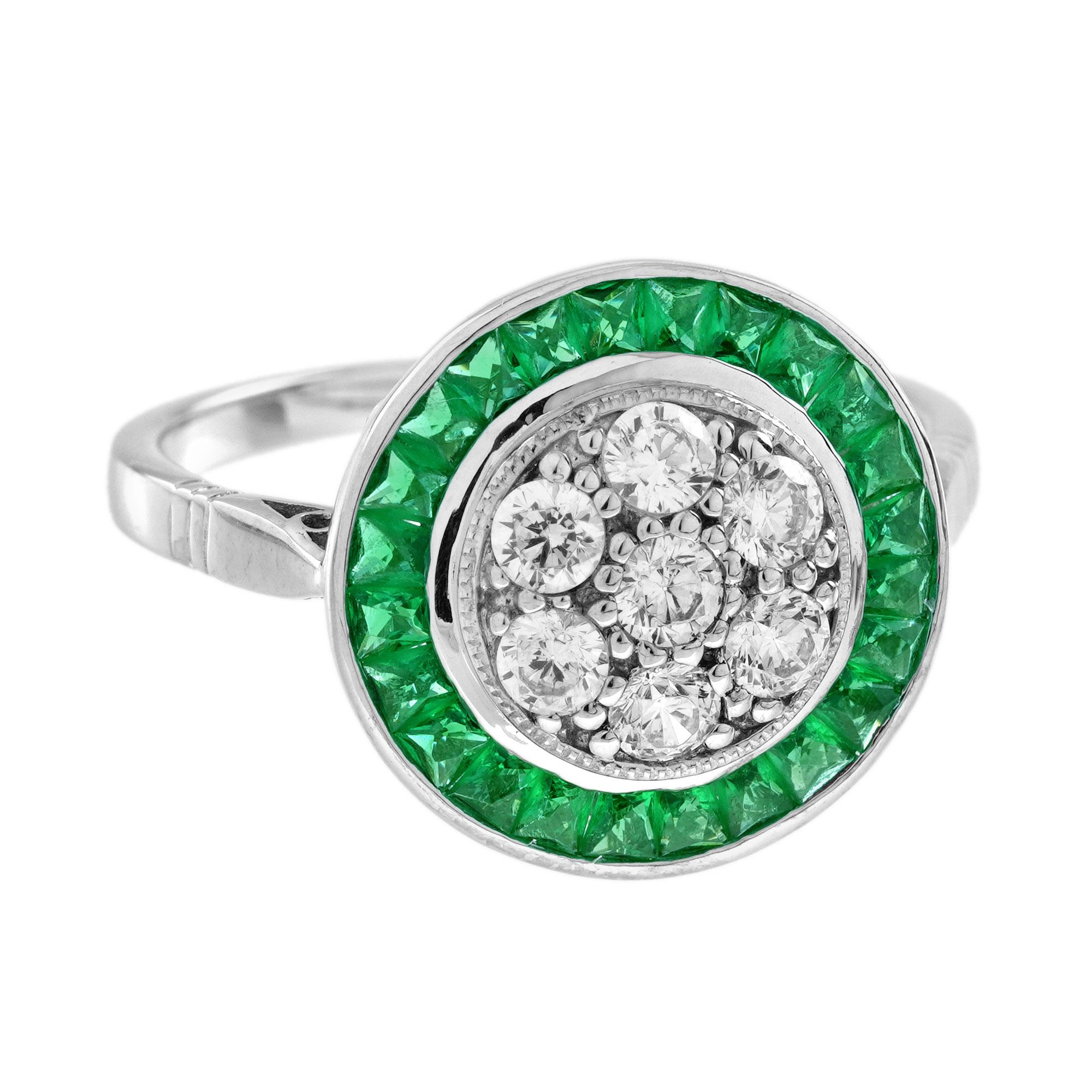 Célébrez l'élégance et la sophistication avec cette étonnante bague cible de style Art déco, qui présente en son centre une grappe de diamants rayonnants, entourée d'émeraudes brillantes. Le motif géométrique, inspiré par le glamour audacieux et