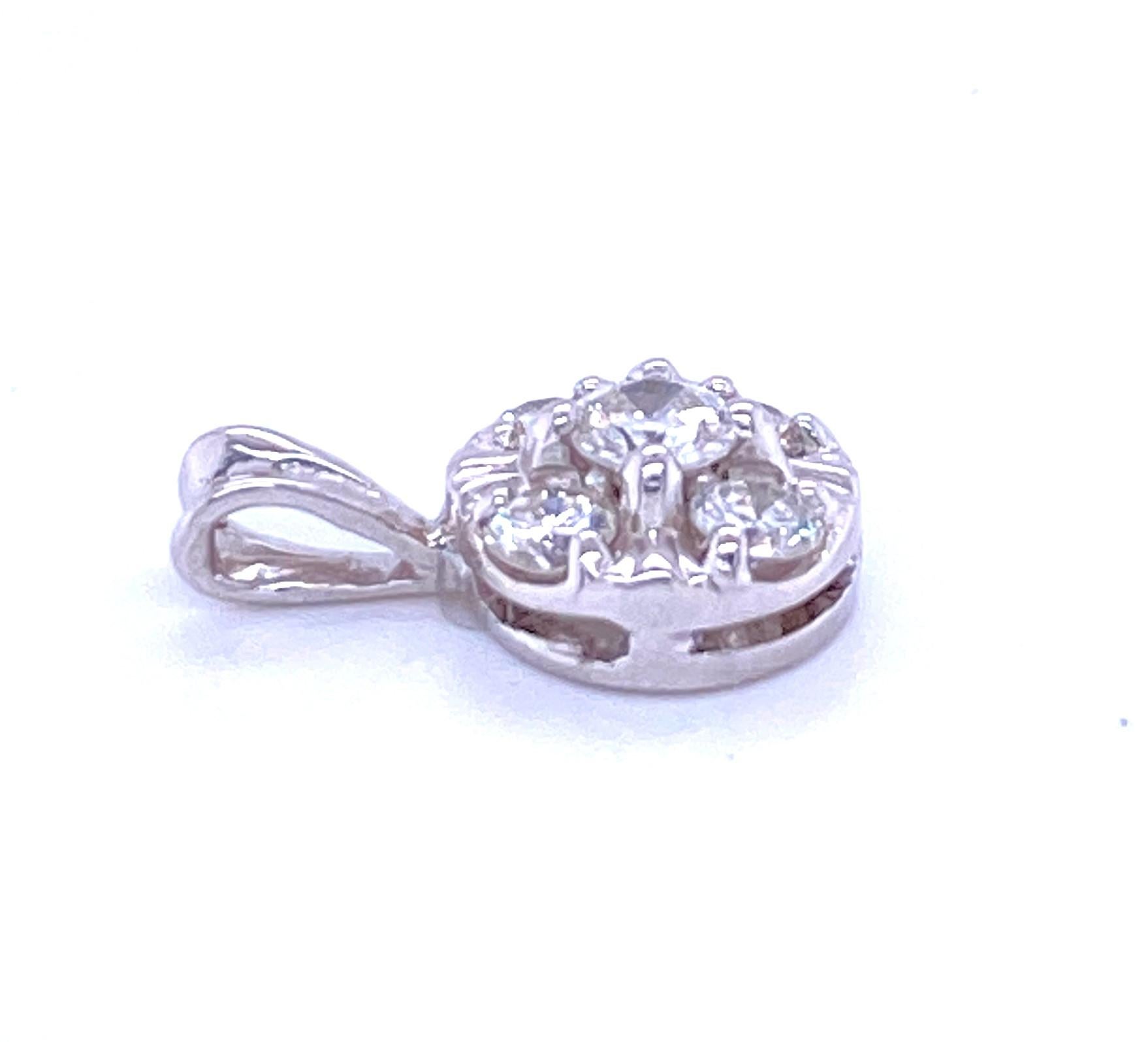 One 14 karat white gold (stamped 14K) cluster style pendant measuring 9mm in diameter prong set with one 3.5mm center round diamond surrounded by four 2.5mm round diamonds, approximately 0.35 carat total weight with matching H/I color and SI1/SI2