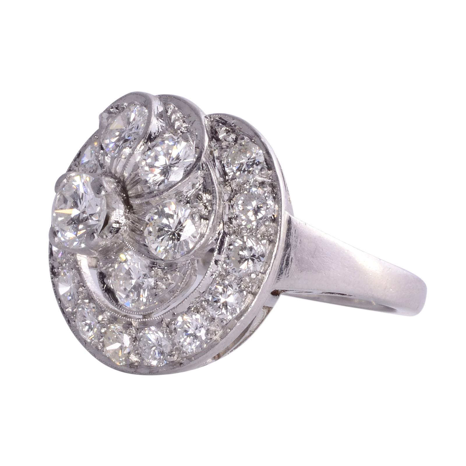 Vintage diamond cluster platinum ring, circa 1940. This vintage platinum ring features a center round brilliant diamond at .27 carat with VS clarity and H-I color. There are four more diamonds set in the petals at .50 carat total weight having