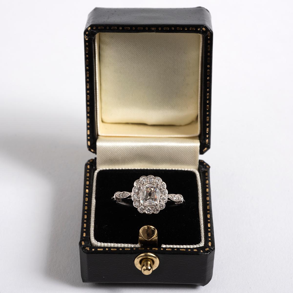 A unique piece within our carefully curated Vintage & Prestige fine jewellery collection, we are delighted to present the following:

Our notable diamond cluster ring has a platinum band and features an old cushion cut centre diamond, est. 1.03ct