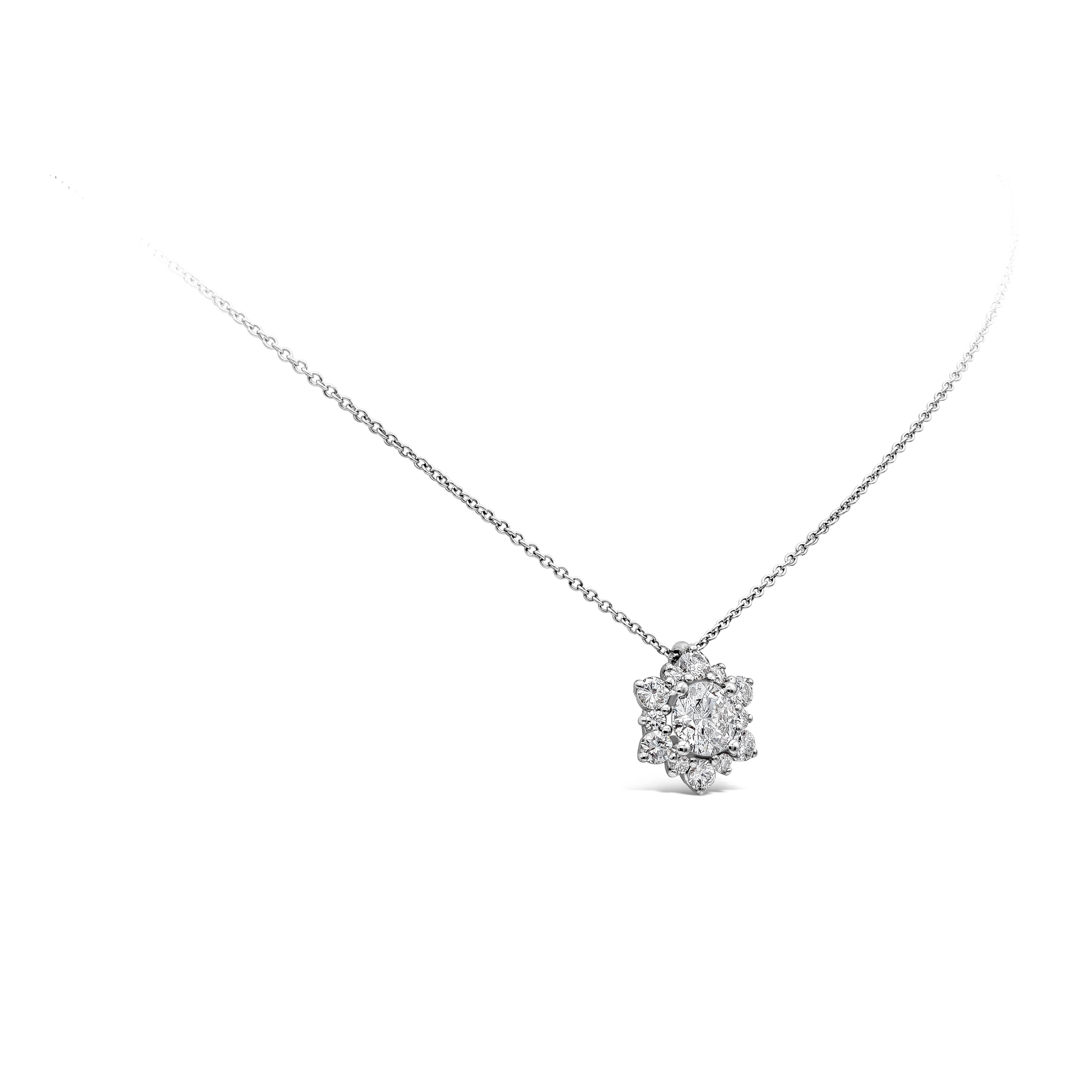 Ce collier pendentif simple et époustouflant met en valeur un diamant rond de 0,76 carats au centre, entouré de diamants éblouissants pesant 0,49 carats au total, dans un halo complexe en forme d'étoile. Finement réalisée en or blanc 18 carats, elle