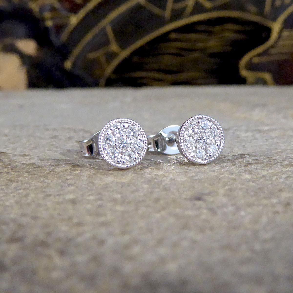 Ein wunderschönes Stück, das durch sein minimalistisches und schönes Design die Schönheit der Zeit zeigt. Diese wunderschönen Diamant-Ohrstecker wurden im Cluster-Stil gefertigt, mit einem Diamanten in der Mitte, der von 6 gleich großen Diamanten