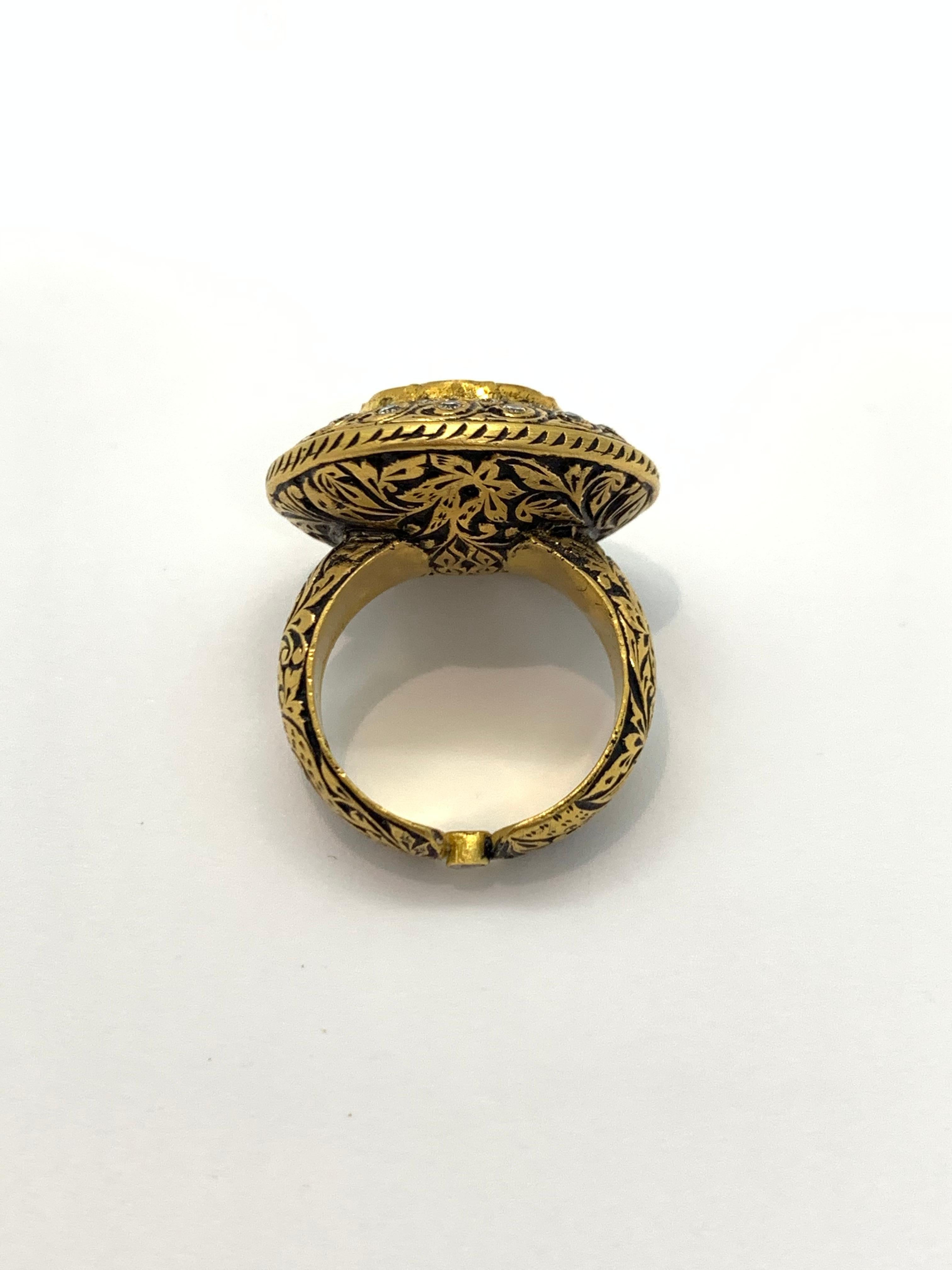 A beautiful cocktail ring with a big uncut diamond centre, and enamel Work all around the ring. 
The uncut diamond is called “polki”, these diamonds have been used in Indian and Mughal Jewelery for centuries.The art of setting the stones is similar