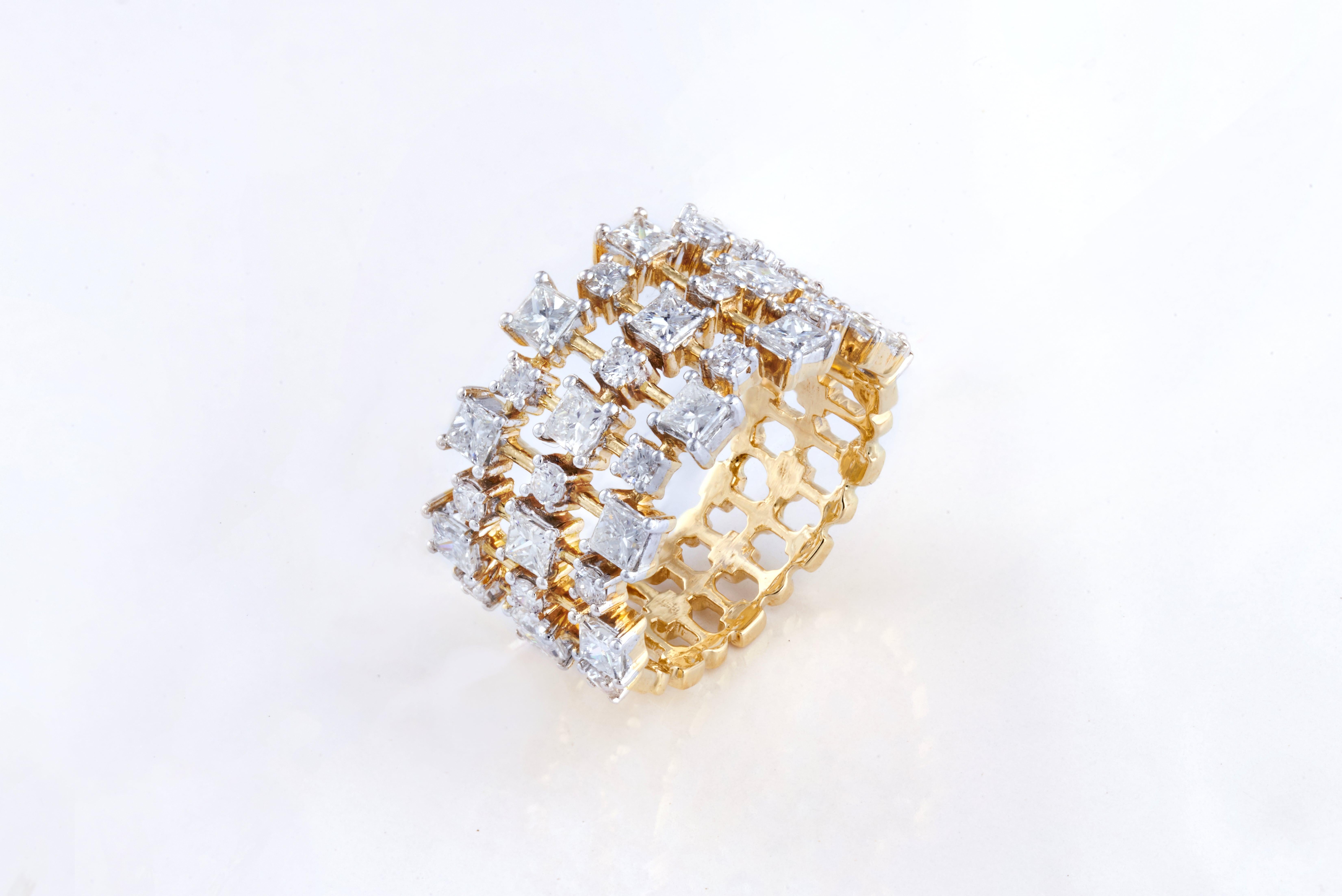 The Ring is studded with 17 round cut Diamonds and 16 Princess cut
Diamonds of VS quality and G colour weighing 2.09 carats, set in 6.93 grams of 18K Yellow Gold. 

These diamonds have been carefully picked and selected from authentic sources and