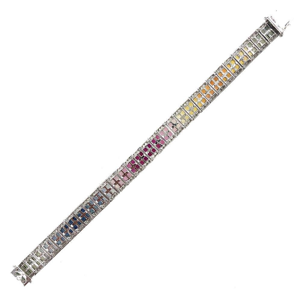 Colorful sapphire and diamond line bracelet fashioned in 14 karat white gold. The bracelet features hues of blue, green, yellow, orange, and pink princess cut sapphires. There are 186 round brilliant cut diamonds equaling approximately 2.00 carat