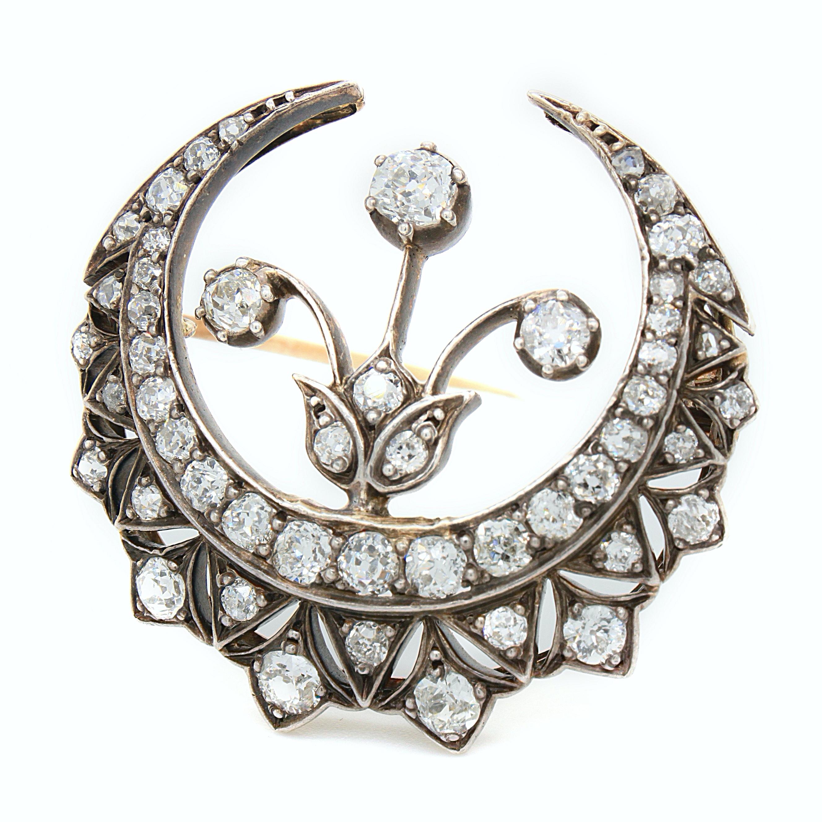 Broche victorienne en forme de croissant et de fleur en diamant, en argent et en or, vers les années 1880. 

Le croissant a un beau dessin avec une fleur attachée au centre, créant un bijou esthétique et symbolique.
La broche est sertie de nombreux