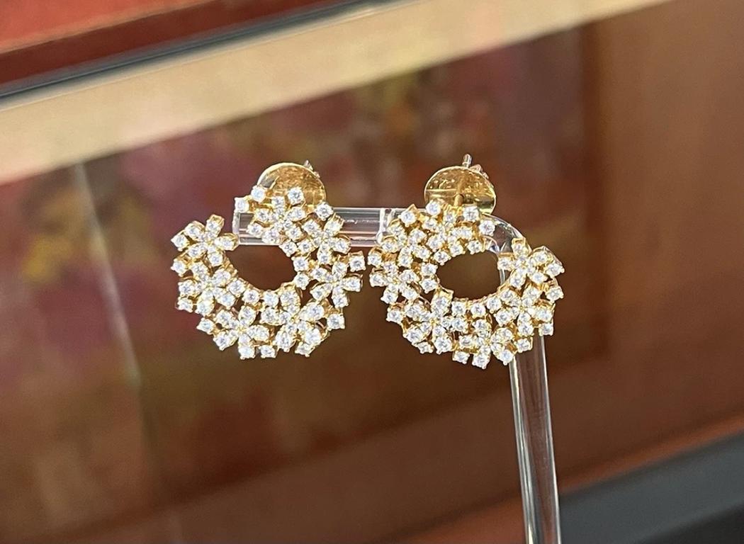 Boucles d'oreilles croissantes en or jaune 18 carats avec motif de fleurs

Les boucles d'oreilles en diamant en forme de croissant présentent des diamants ronds et brillants avec des motifs en forme de fleur, le tout serti dans de l'or jaune 18k.