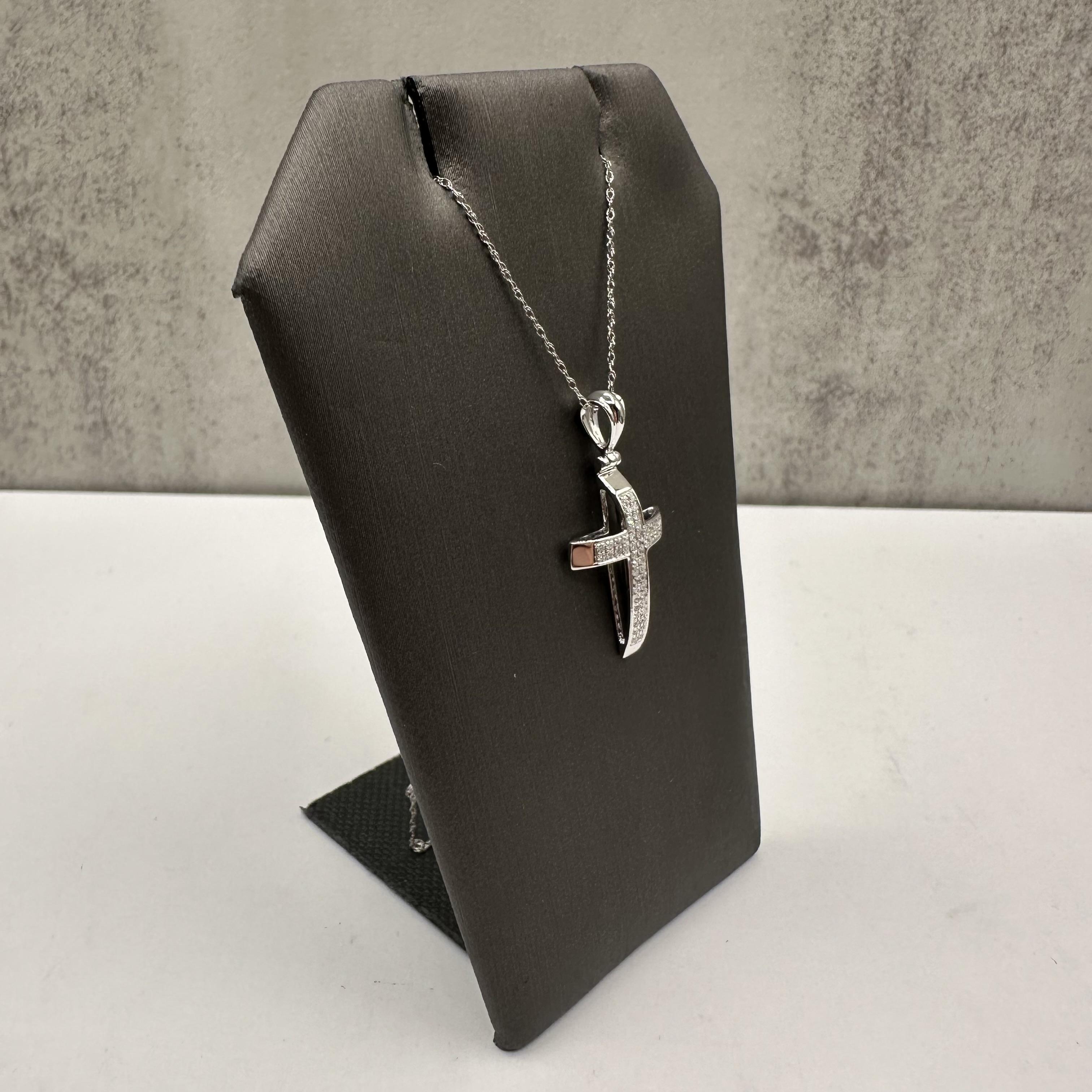 Cet élégant collier croix en diamant, réalisé en or blanc 14kt, offre un beau mélange de foi et de style. Avec un poids total de 0,12 carat (ctw) de diamants ronds de couleur HI et de pureté I1, le pendentif en forme de croix brille subtilement pour
