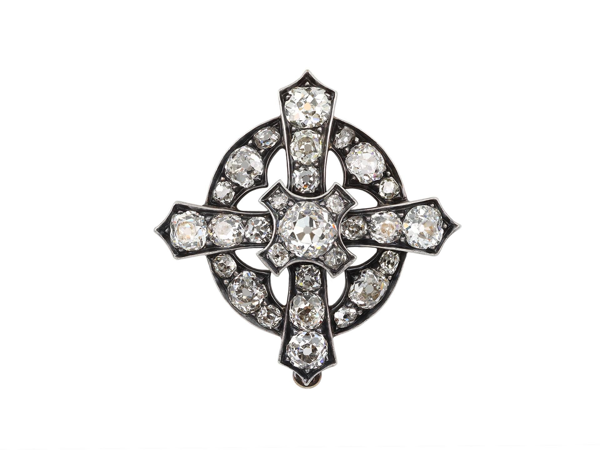 Diamond cross pendant / brooch. Set to centre with a cushion shape old mine diamond in an open back grain setting with an approximate weight if 0.65 carats, further set with twenty-eight cushion shape old mine diamonds in open back grain settings,