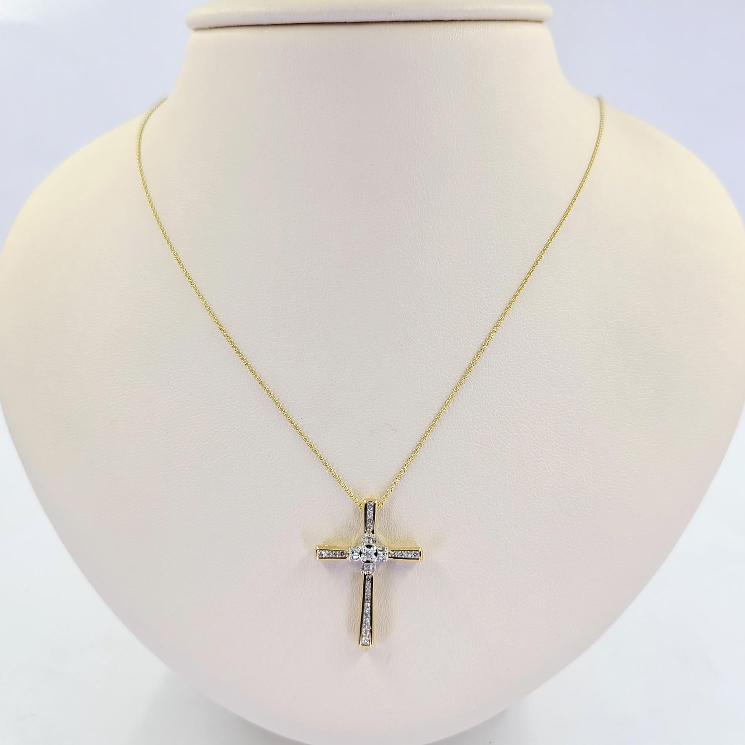 14 Karat Yellow Gold Cross Pendant Necklace Featuring 24 Round Brilliant and Baguette Cut Diamonds of SI Clarity and H/I Color Totaling Approximately 0.12 Carats. 16 Inch Rolo Chain with 1 Inch Pendant. Finished Weight Is 2.1 Grams.