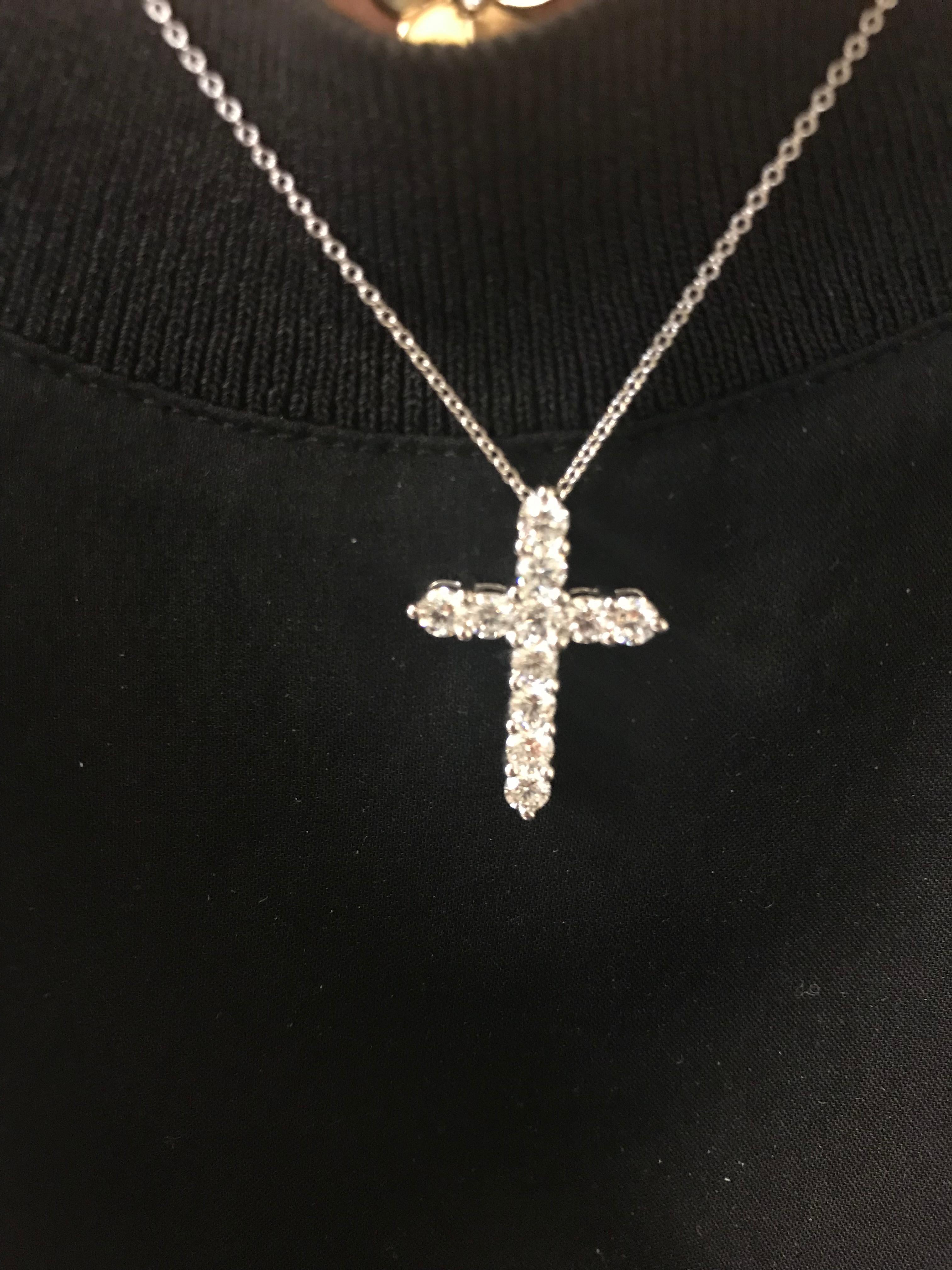 Diamond cross pendant set in 14k white gold. The carat weight is 1.43. The stones are set in a shared prong. The pendant is set with 11 stones, each weighing 0.12-0.13 carats approximately. The color is G, clarity is SI1.