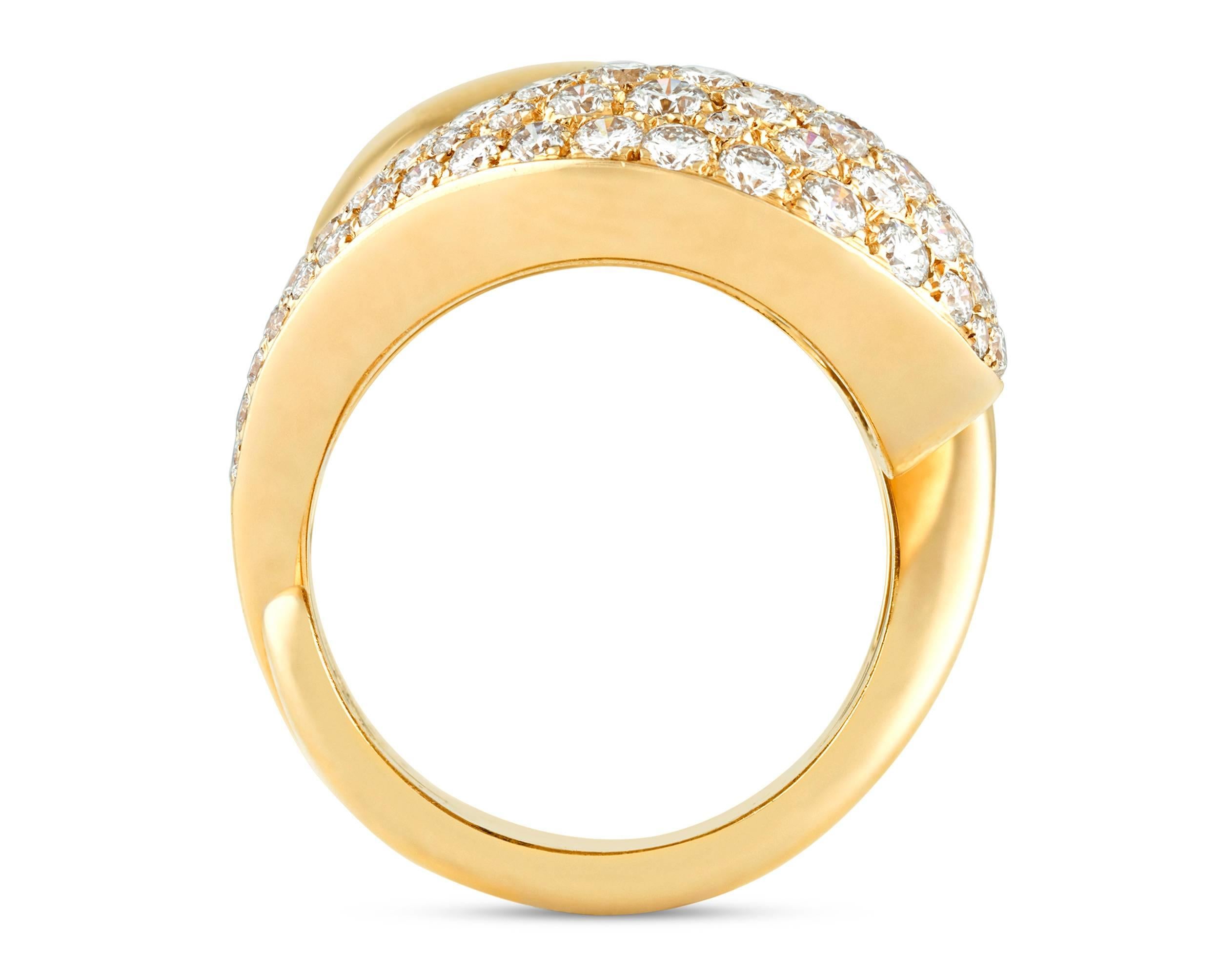 An incredible contemporary design by the legendary Cartier sets apart this exceptional crossover ring. Crafted of 18k yellow gold, the piece is designed as two curved, bombe sections in symmetrical opposition, with one side pavé set with