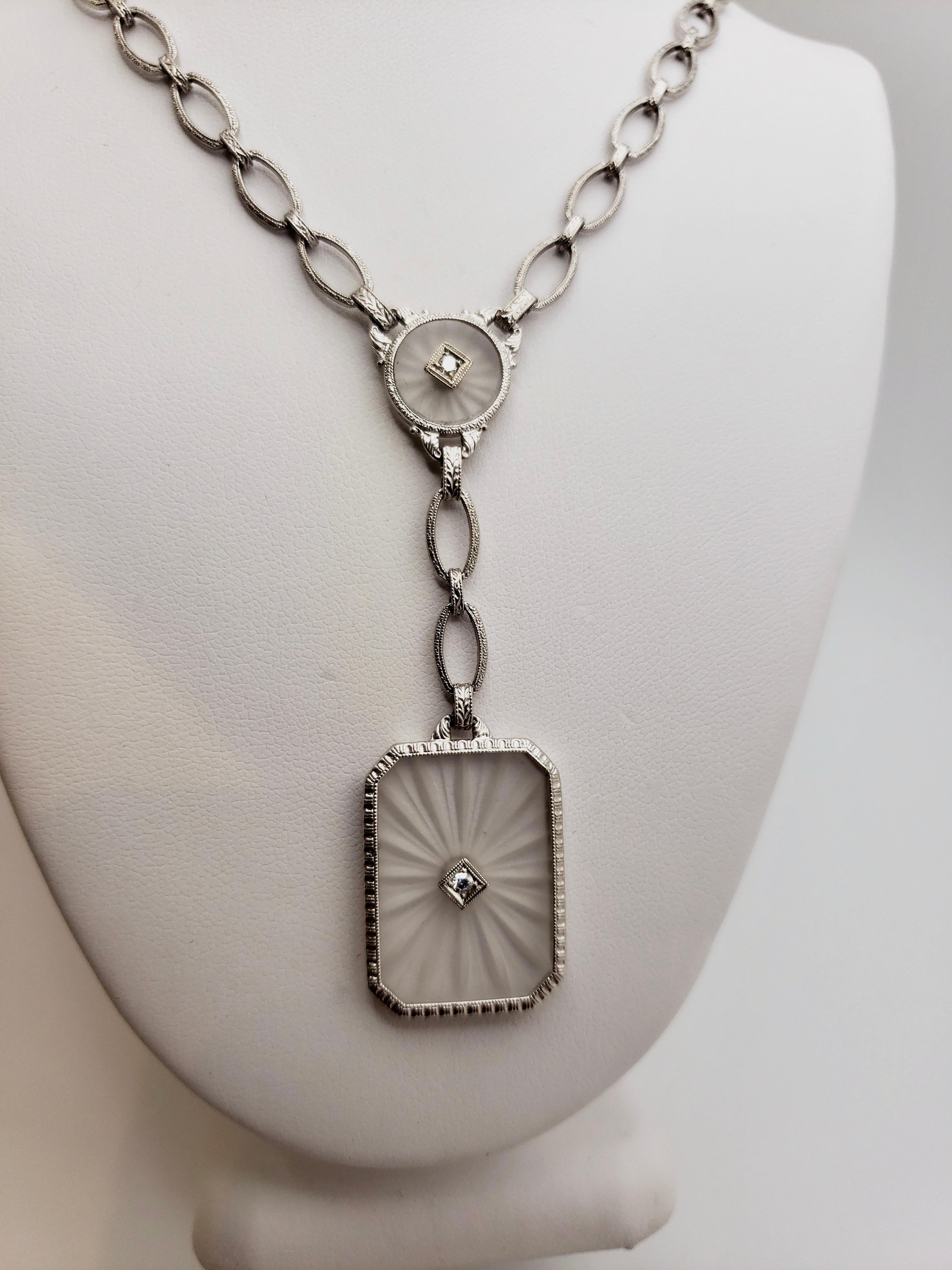 An original handmade diamond platinum and 14K white gold carved crystal necklace, circa 1950's. The beautiful link chain is accented by the engraved pattern on each link. A circular carved sun-ray crystal accented by diamonds bonds the chain, with