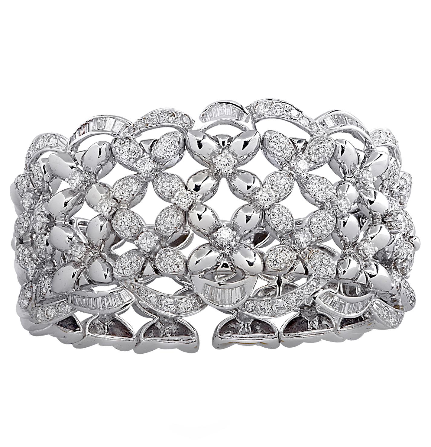 Stunning cuff bangle bracelet crafted in 18 karat white gold, featuring round brilliant cut and baguette cut diamonds weighing approximately 6.73 carats total, G-I color, VS-SI clarity. Delightful flowers adorned with diamonds interlock and are