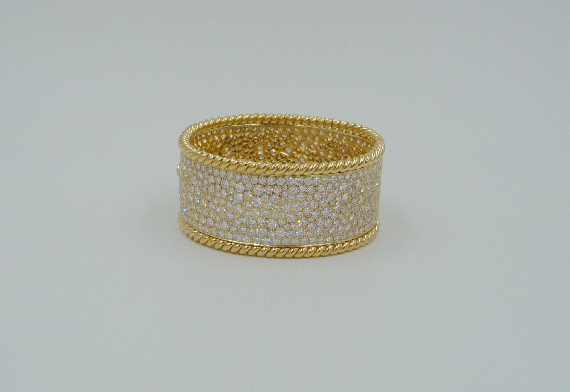 Una auténtica declaración de artesanía y lujo, esta pulsera brazalete hecha a medida está fabricada totalmente a mano en oro macizo de 18 quilates, disponible en oro amarillo, blanco o rosa a elegir. El atrevido diseño está engastado en pavé con