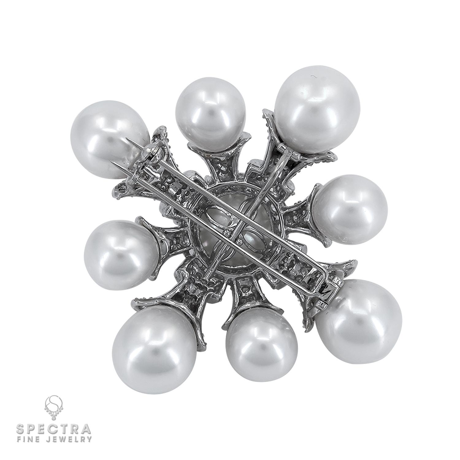 Un'armonia di eleganza e maestria, questa spilla con ciondolo di diamanti e perle coltivate è un pezzo raffinato. Al centro si trova una luminosa perla coltivata di circa 15,00 mm, che emana un fascino senza tempo. Otto raggi tempestati di diamanti