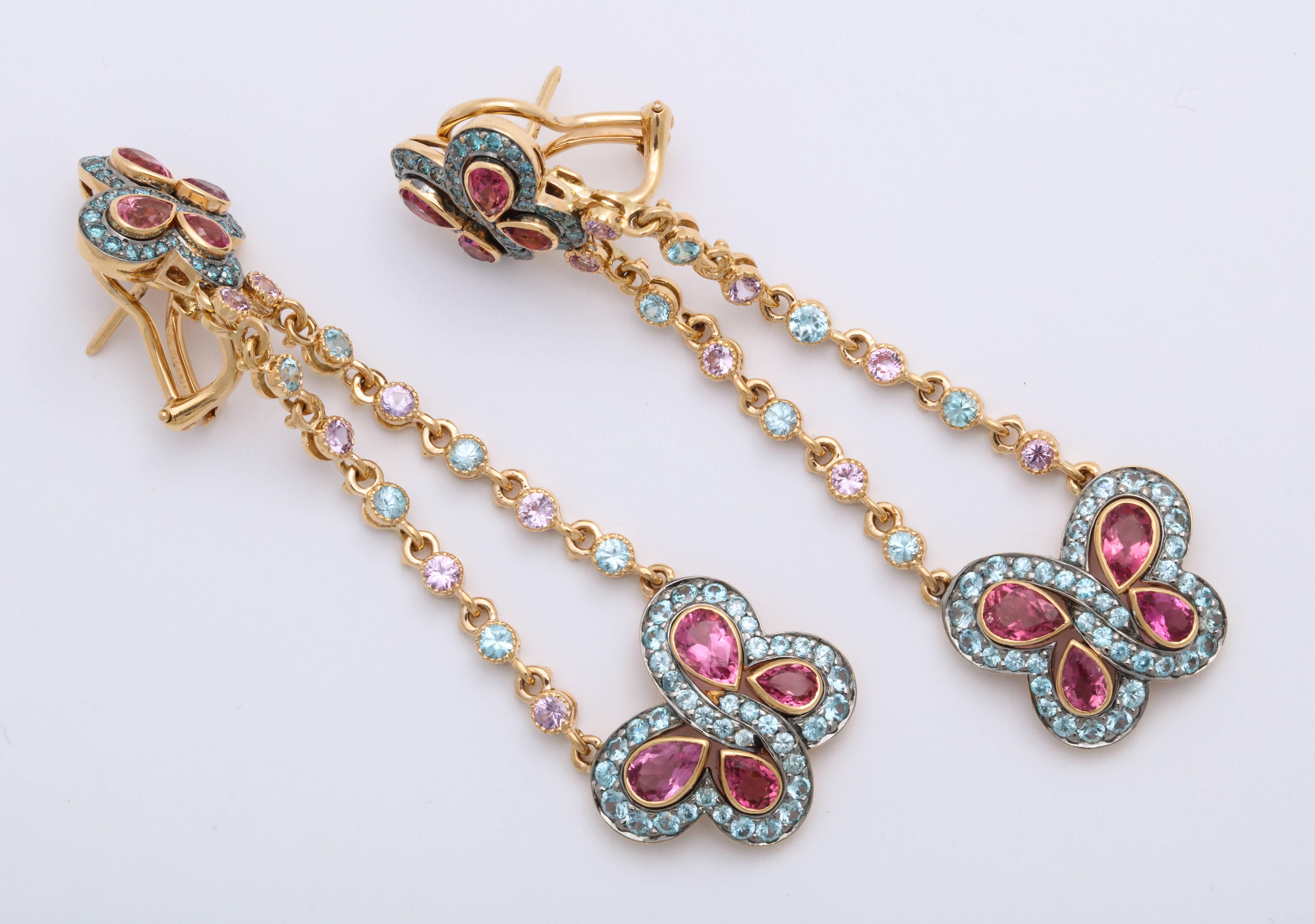 These colorful and bright earrings are sure to make a statement!  These 18 karat rose gold butterfly ear pendants are suspended from trapeze swing, with collet set diamond-cut pink sapphires: 1.48 carats and colorless diamonds: 0.91 carats, attached