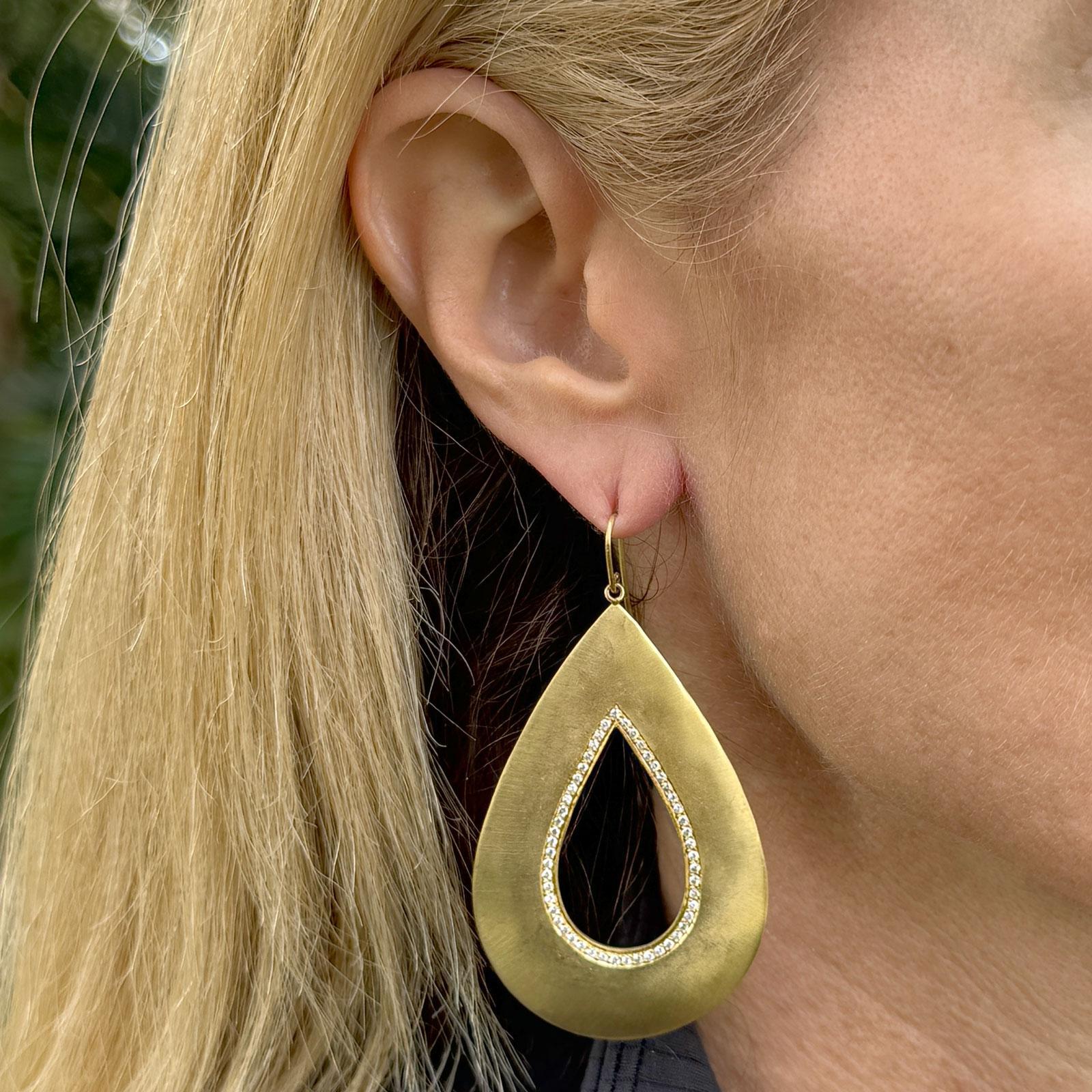 Élégantes et accrocheuses, ces boucles d'oreilles pendantes en or jaune 18 carats présentent une finition brossée raffinée et une gracieuse silhouette en forme de poire. Sertis de 102 diamants ronds de taille brillant totalisant environ 1,00 carat