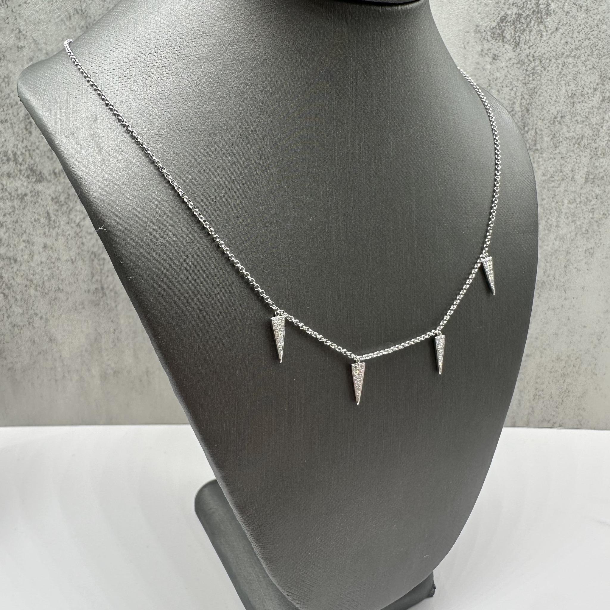 Questa elegante collana con diamanti penzolanti in oro bianco 18 carati presenta un peso totale di 0,15 carati di diamanti tondi naturali GH VS/SI, che offrono uno scintillio brillante in un design delicato e raffinato. La catena regolabile in stile