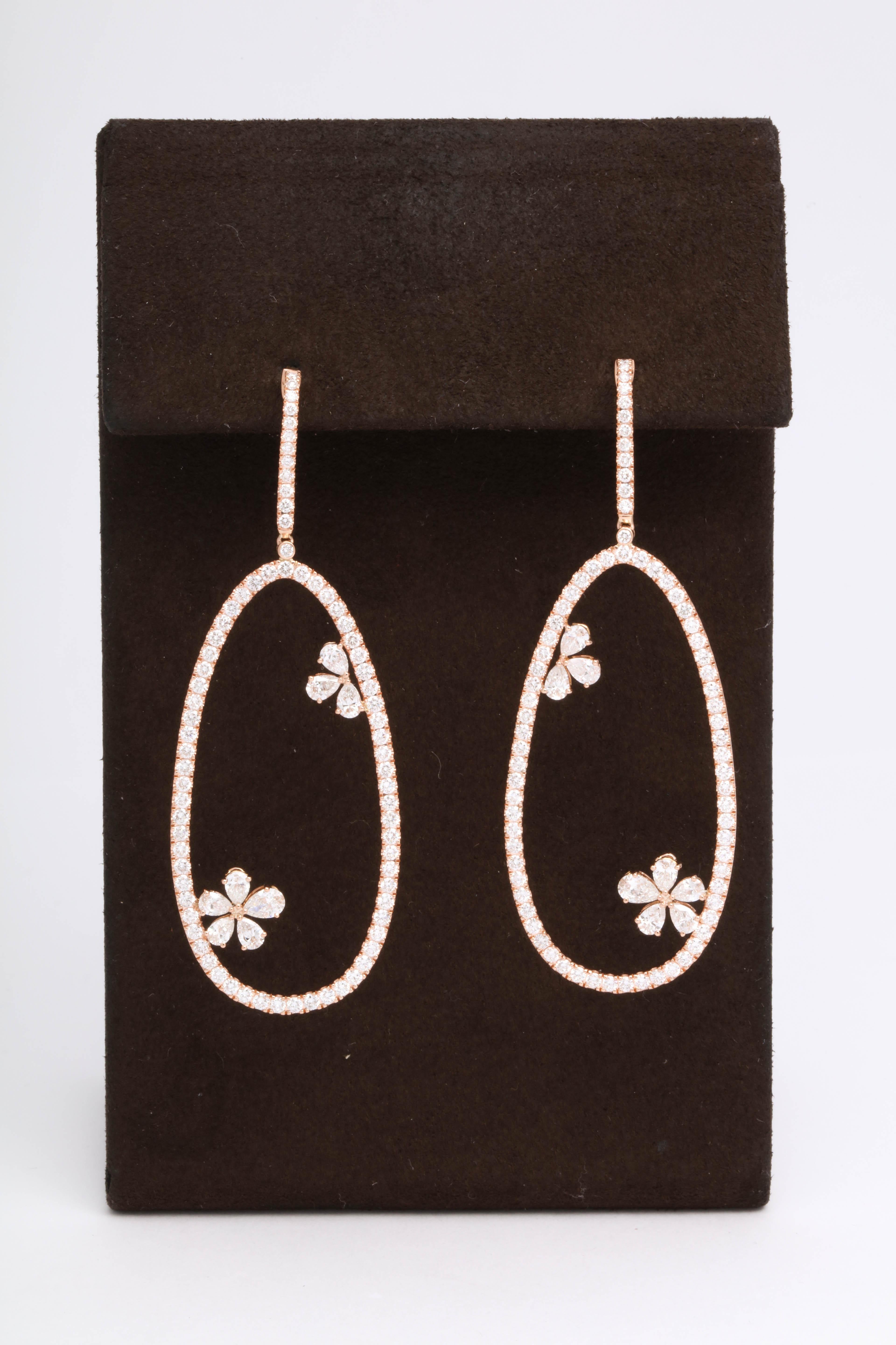 

A unique diamond dangle earring set in 18k Rose gold. 

4.42 carats of white round brilliant cut and pear shaped diamonds. 

Approximately 2.55 inches in length, just under an inch at its widest point. 
