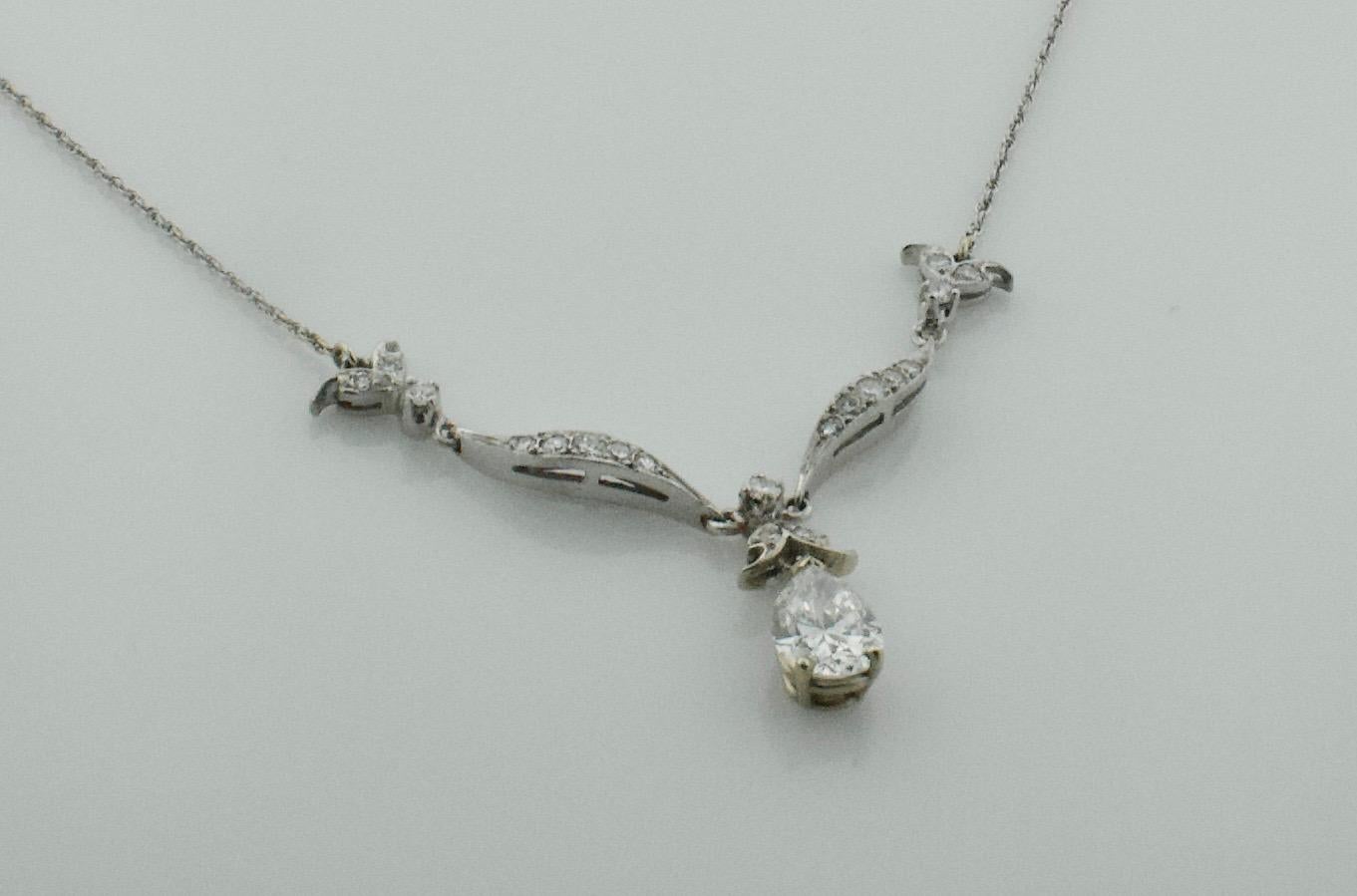 Diamond Dangling Pear Shape Necklace in Platinum on 14k Chain c. 1950's
One Pear Shape Diamond Weighing 1.21 GIA Certified G I1 [bright with no imperfections visible to the naked eye]
Seventeen Round Cut Diamonds weighing .45 carats approximately