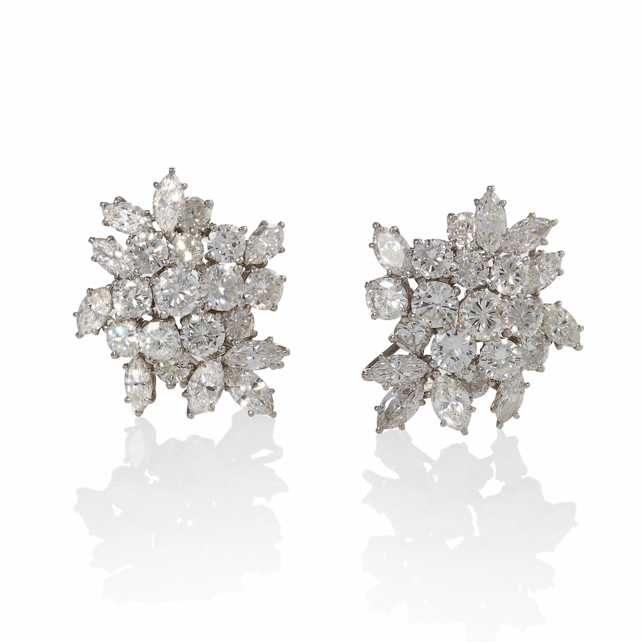 Dating from the 1950s-1960s, these platinum day/night clip pendant earrings are set with over 30 carats of diamonds. The abstract high relief cluster tops, set with approximately 7.10 carats of round brilliant-cut diamonds, suspend detachable