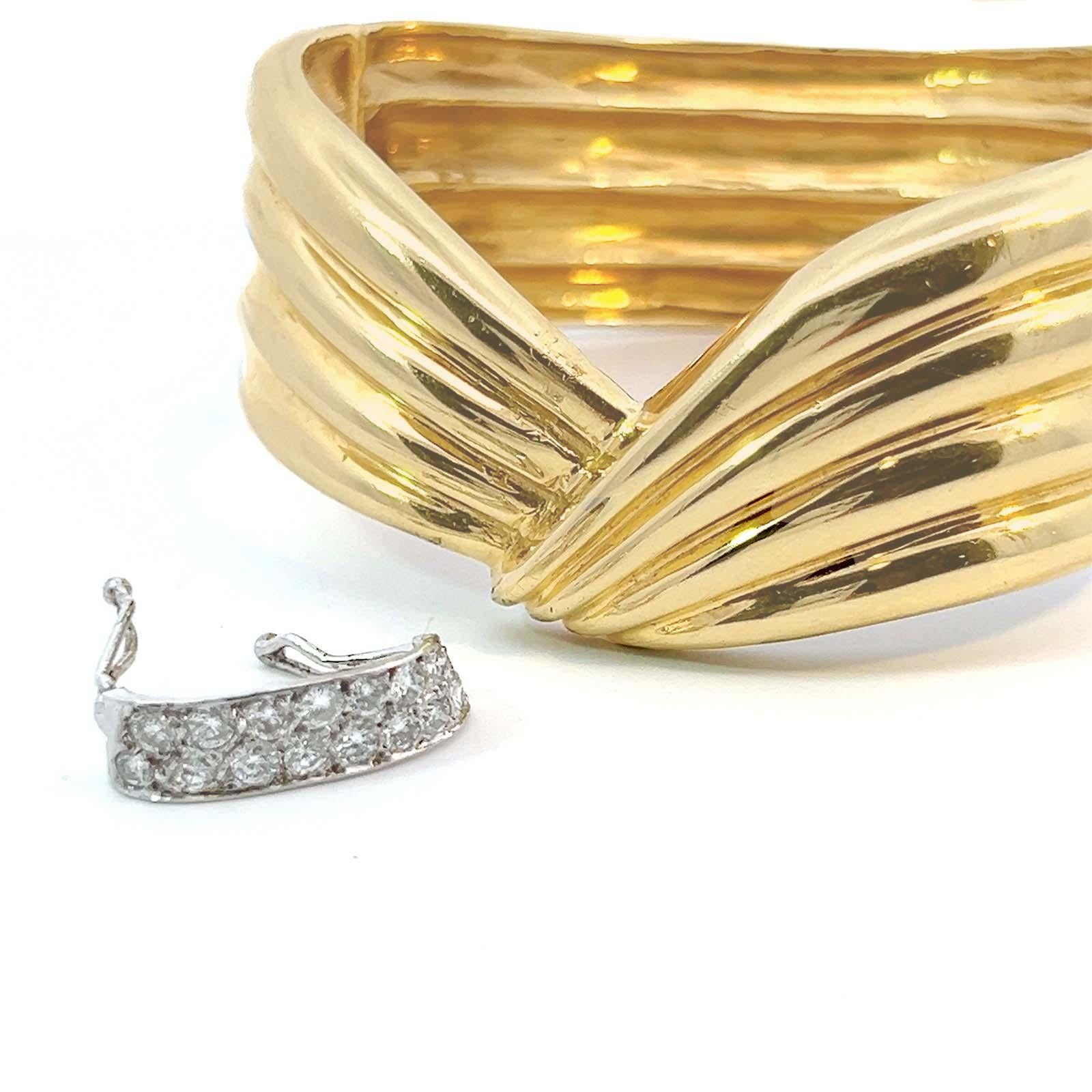 Late 20th Century, 1980's, vintage 0.75 ctw. diamond bangle bracelet in 14k yellow and white gold. The day/night-style design features a cinched bracelet gleaming in 14k yellow gold sparked with a stripe of 15 round brilliant cut diamonds, G-I
