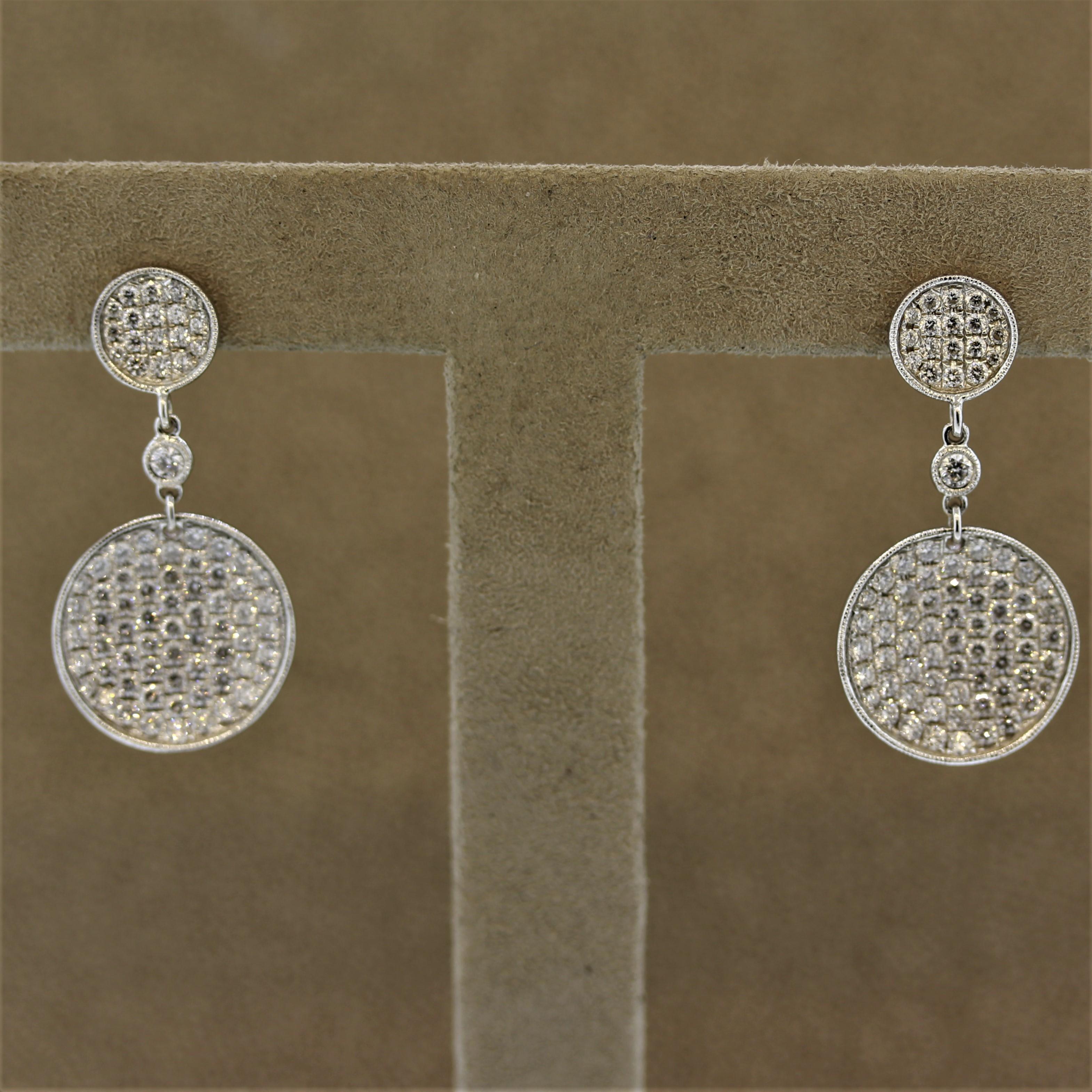 A chic and stylish pair of drop earrings featuring 2.32 carats of round brilliant cut diamonds set on round discs of 18k white gold. The chain-drop between the two discs feature a larger round cut diamond which adds to the style. Can be worn