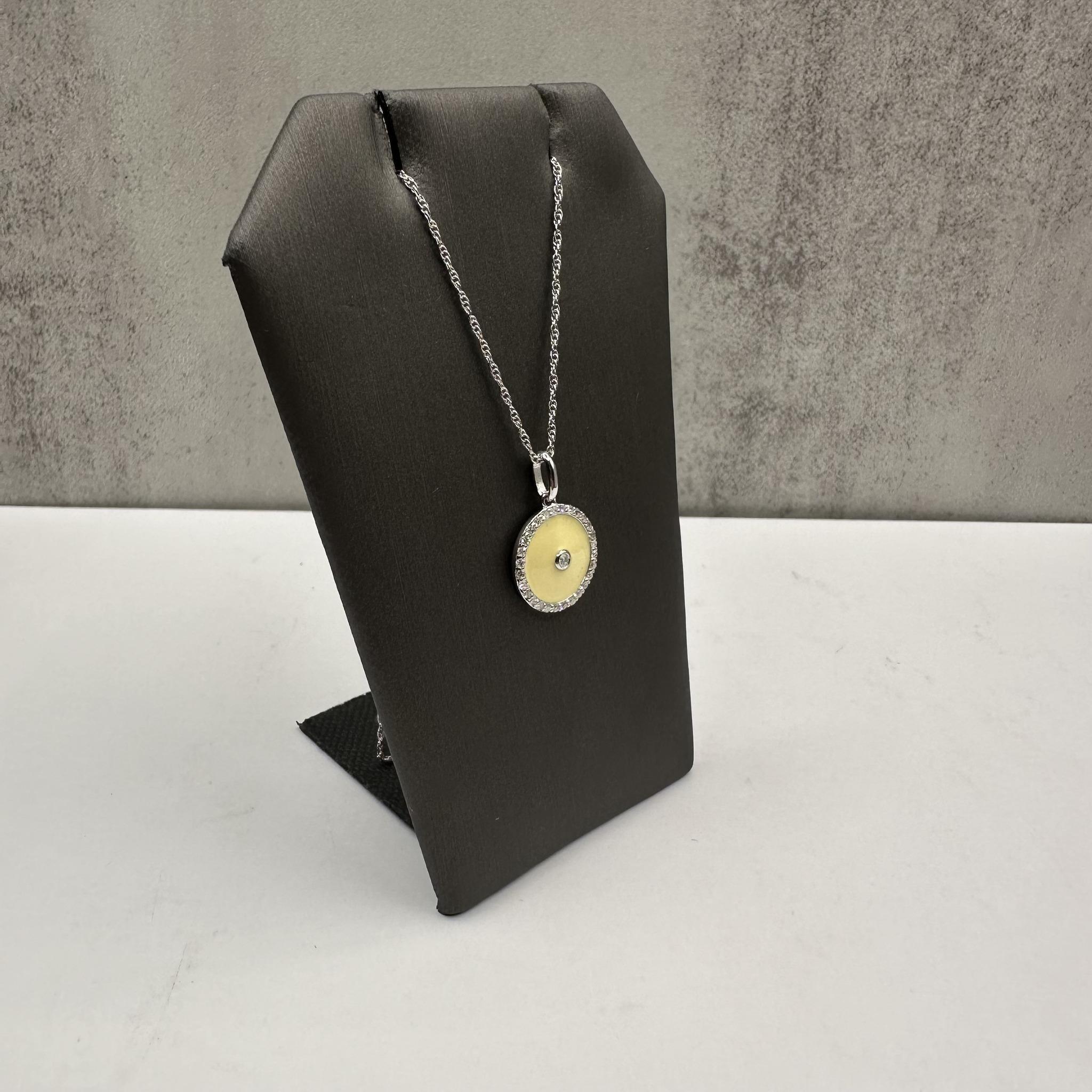 This elegant Diamond Disc Necklace in Sterling Silver features 0.20 carat total weight (ctw) of natural HI color I1 clarity round full cut and single cut diamonds, set in a sleek disc pendant. The pendant is adorned with yellow-tan enamel, offering