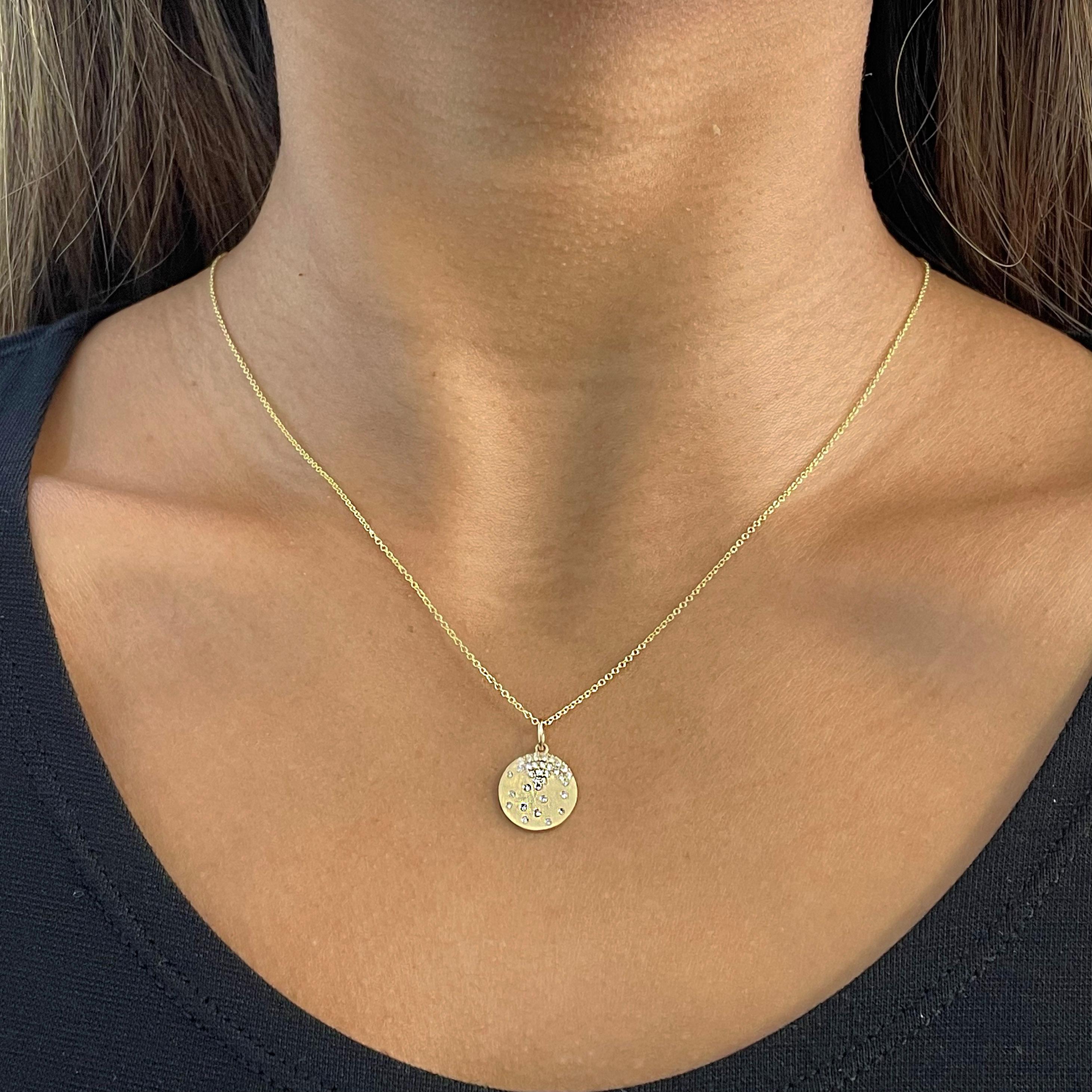 This confetti necklace contains a round pendant with small round diamonds placed in a seemingly random fashion to create one of the most beautifully unique pieces of jewelry. It resembles confetti falling from the top and is perfect on its own or