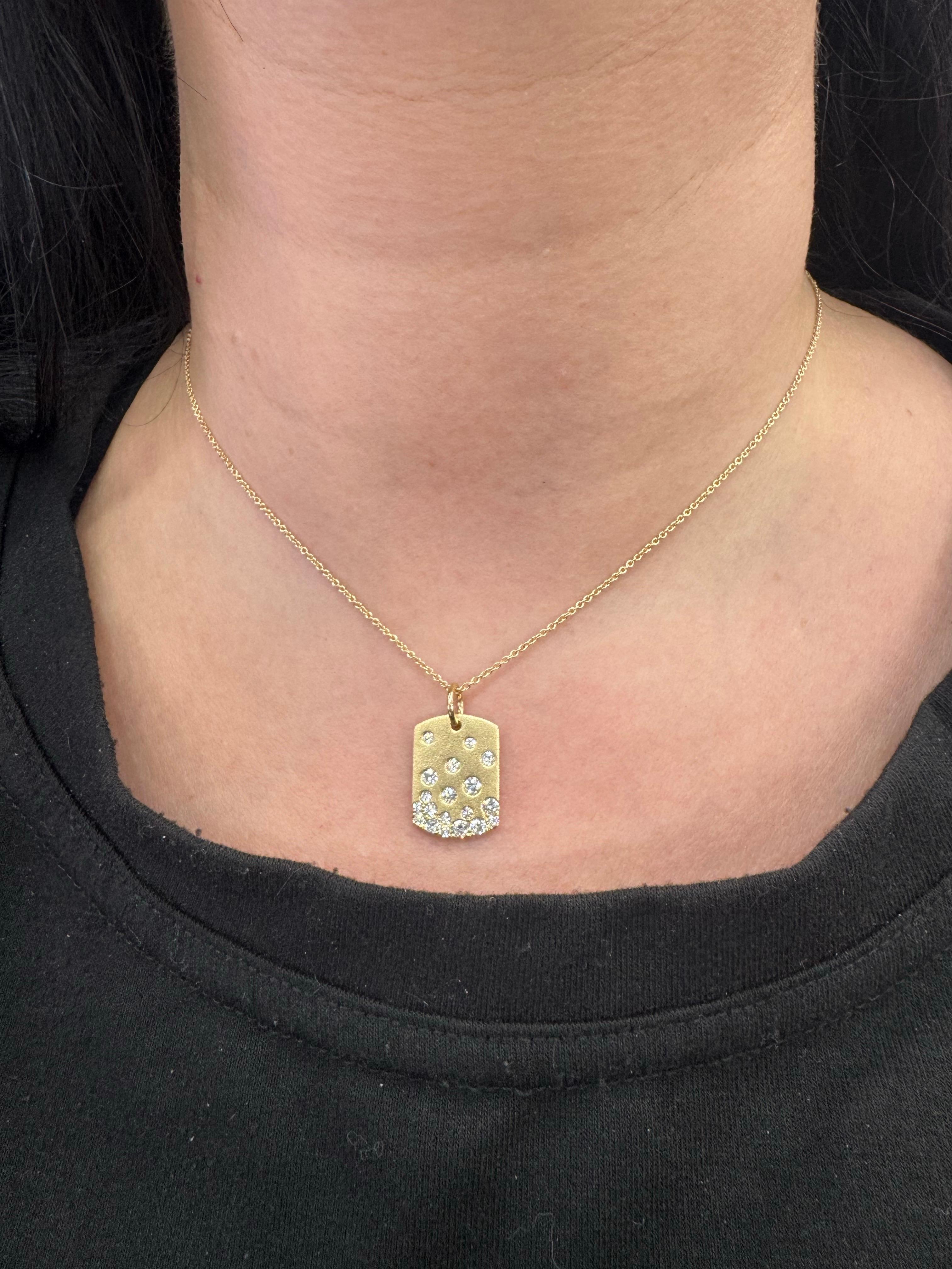 Questo elegante e moderno ciondolo a forma di medaglietta per cani è realizzato in oro giallo 14K e incastonato con 19 diamanti rotondi a taglio brillante per un totale di 0,73 carati. I diamanti sono sparsi ad arte in un giocoso motivo a