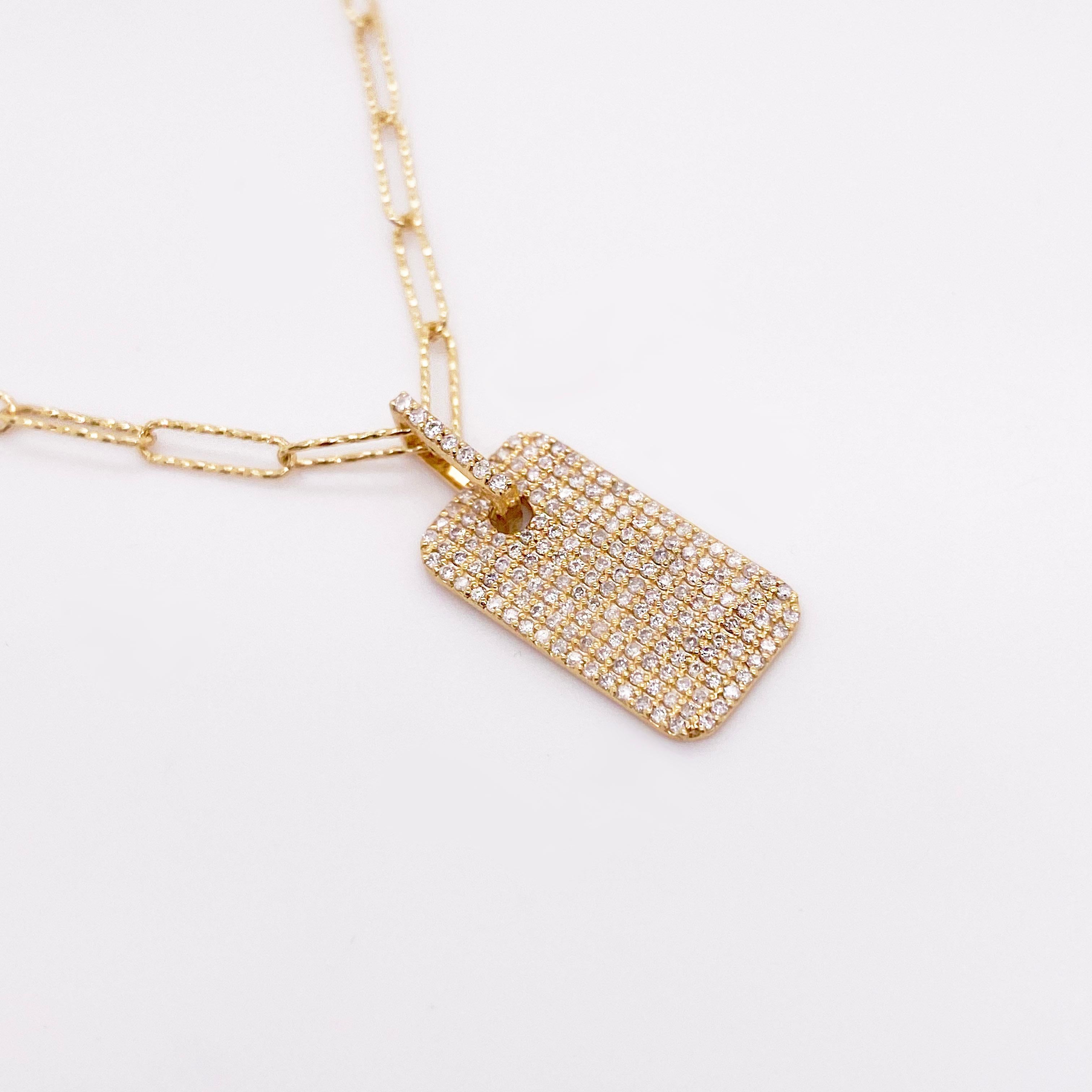 This Dog Tag Necklace is solid 14 karat yellow gold with diamonds that make it sparkle from every angle. The paperclip chain is diamond cut so that it glitters almost as much as the dog tag pendant. This necklace is beyond stunning and a great