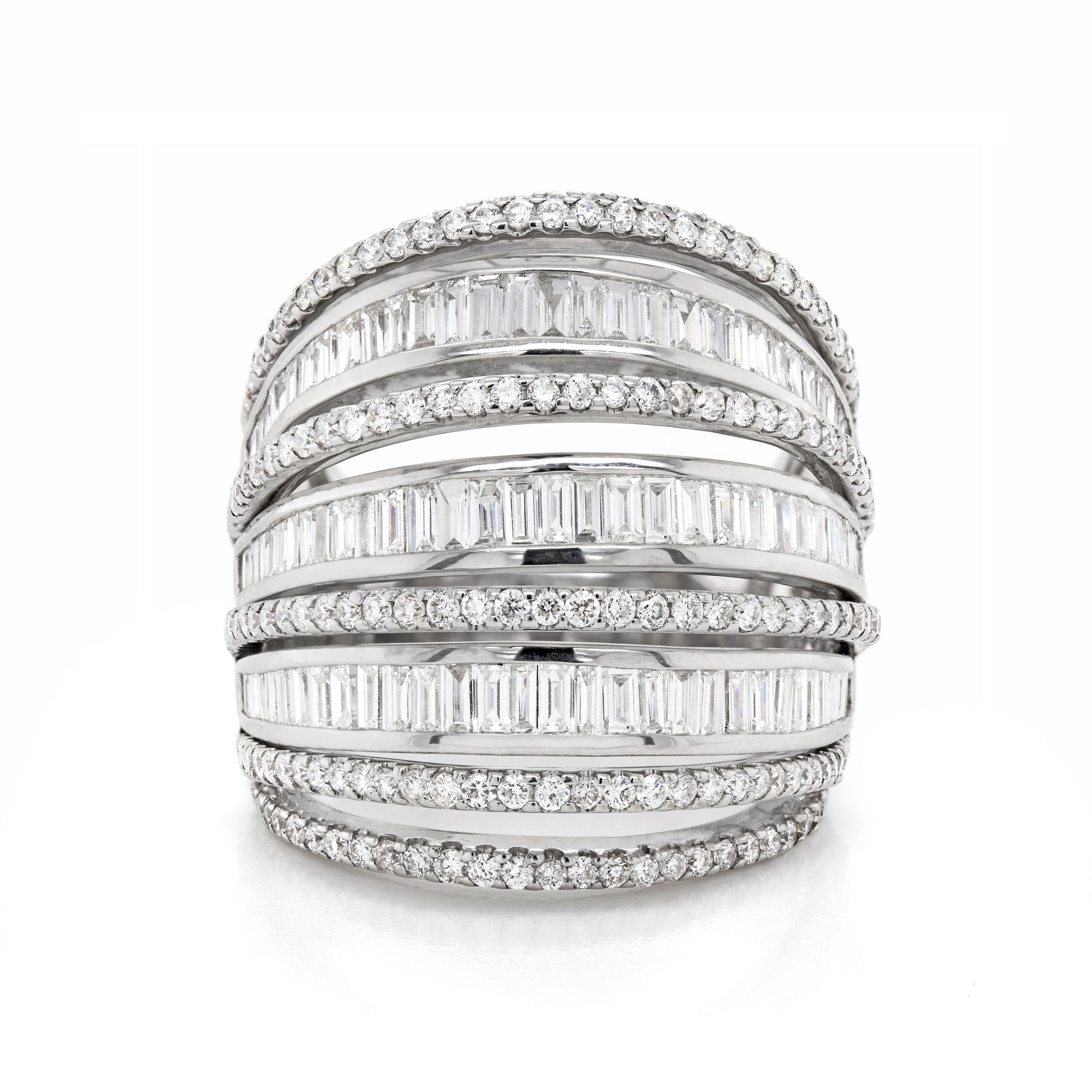 This large ornate cocktail ring is beautifully created with nine diamond set bands all constructed into a domed design. The bands alternate with claw set round brilliant cut diamonds and channel set baguette cut diamonds creating a lovely contrast