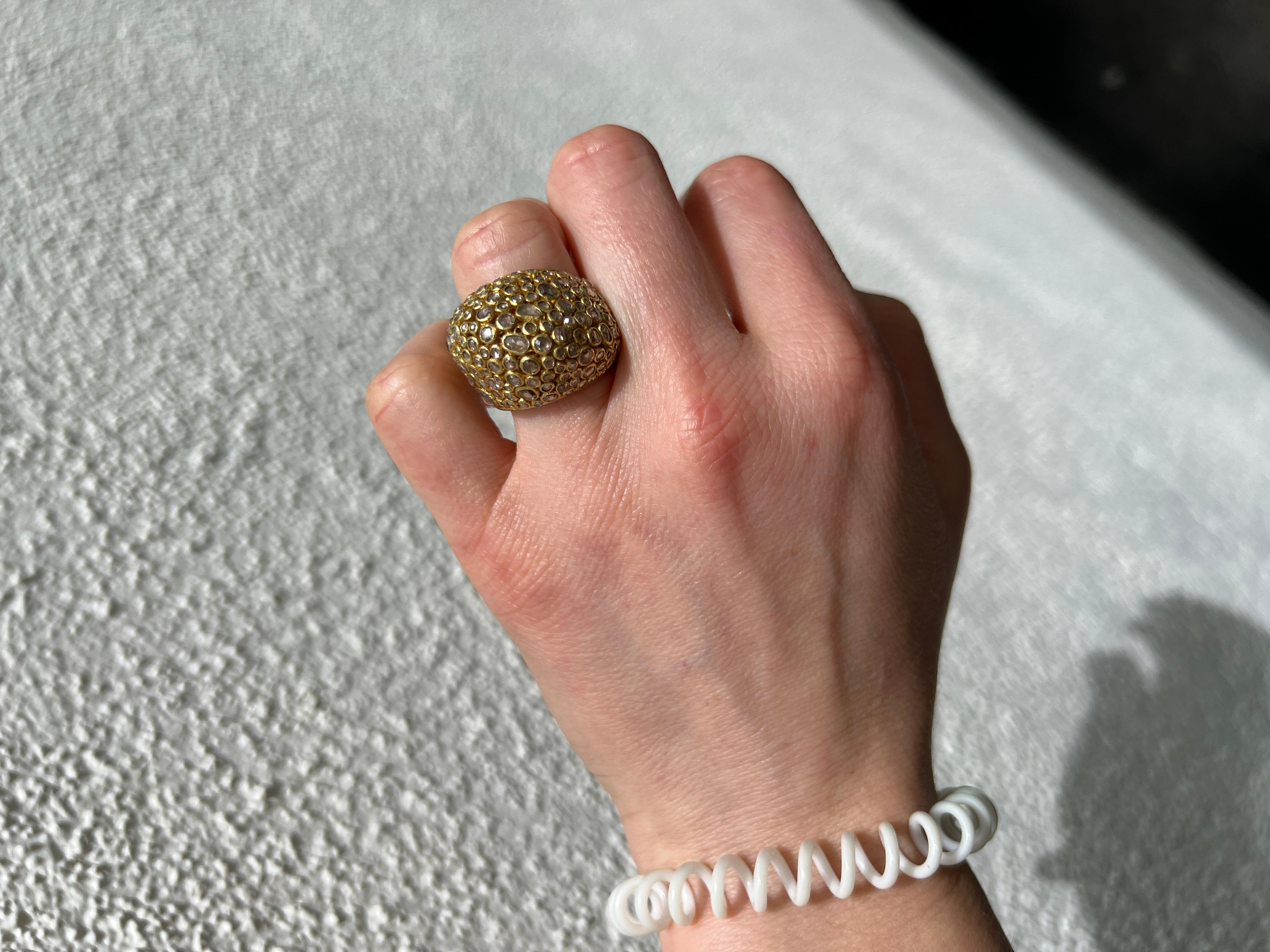 18 karat yellow gold diamond dome cocktail ring. Crafted with meticulous attention to detail, this one-of-a-kind piece boasts a captivating woven design of circles and swirls, exuding sophistication and charm.
Adorned with delicate rose-cut