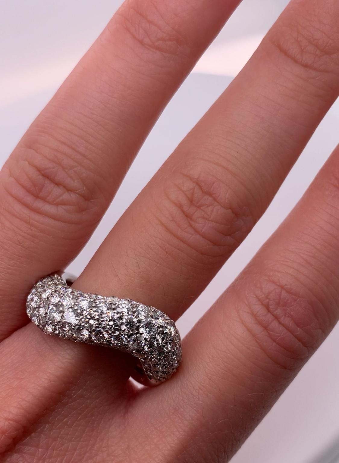 This exquisite engagement ring showcases a stunning 3.50ct diamond in a pavé setting, surrounded by smaller diamonds. Crafted from 18ct white gold, this handcrafted dome ring band is both elegant and durable. The round-shaped, natural diamonds have
