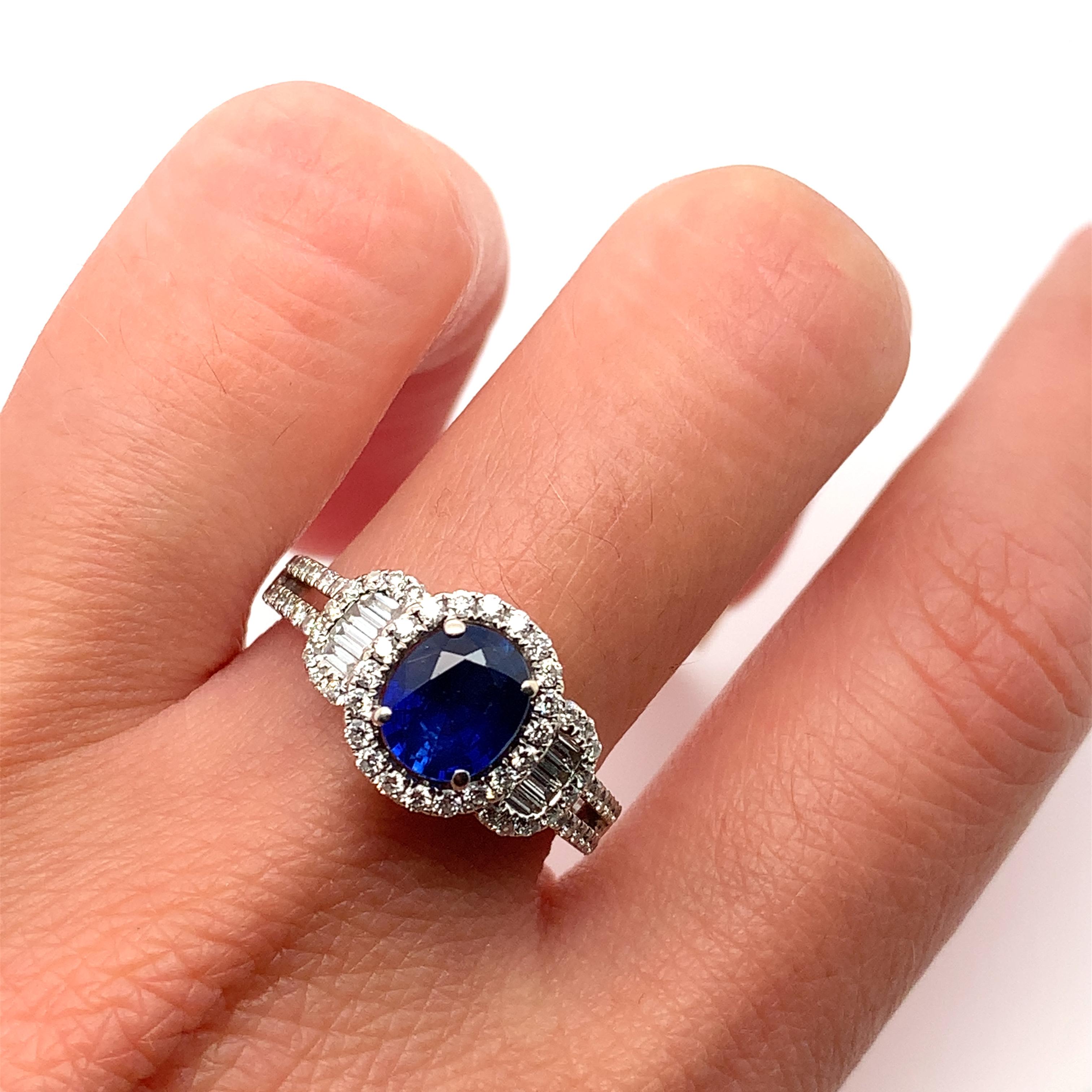 Oval shaped sapphire blue vivid colour total weight 1.27ct 
Art deco style sapphire and baguette diamonds halo engagement ring in 18k white gold.
Round brilliant cut diamond total weigh 1.30ct F colour VS1 clarity
Hallmarked
Size M1/2
The ring can