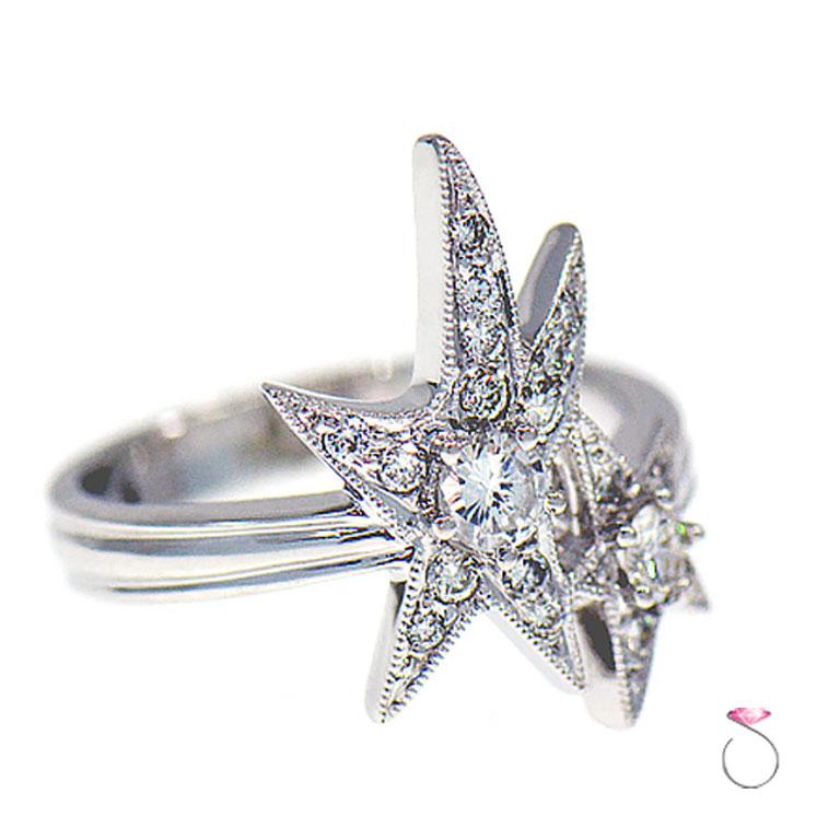 Beautiful diamond double star cocktail ring in 18K white gold. This magnificently crafted ring features a total of approximately 0.60 ct. round brilliant diamonds. The ring design features two stars, each star is set with a large diamond in the