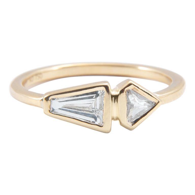 The asymmetrical design of this diamond band gives it a chic modern edge.

18K yellow gold band
Bezel set
0.22 carats of baguette cut diamond
0.12 carats shield cut diamond