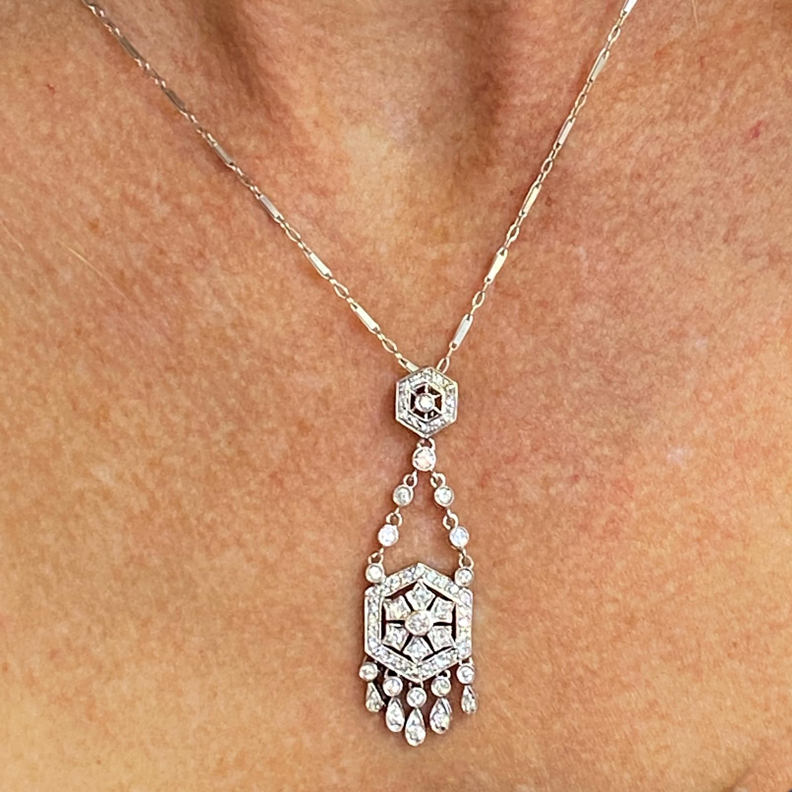 Diamond drop pendant fashioned in 18 karat white gold. The pendant measures 1.75 inches in length, and features 50 round brilliant cut diamonds weighing .86 carat total weight. The diamonds are graded H-I color and SI clarity. The pendant is